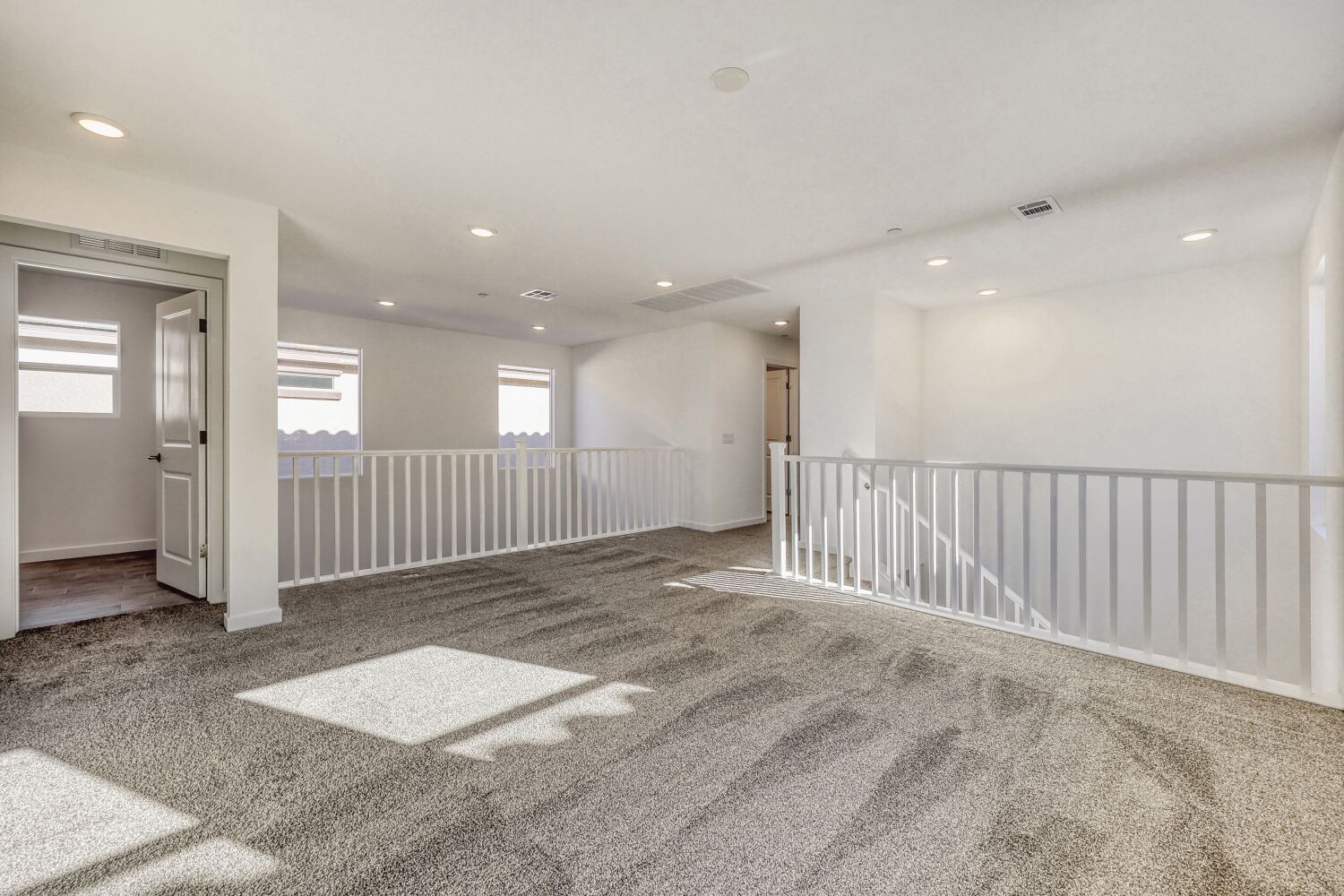 A large room with a white railing.