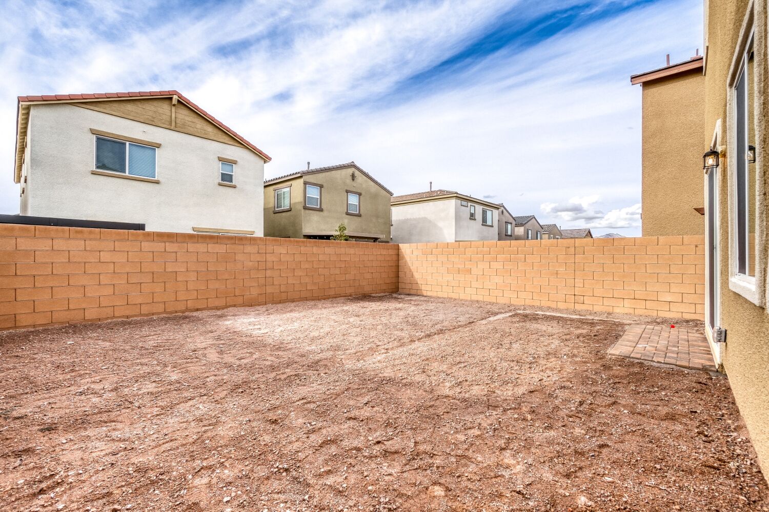 A dirt yard with buildings in the background.