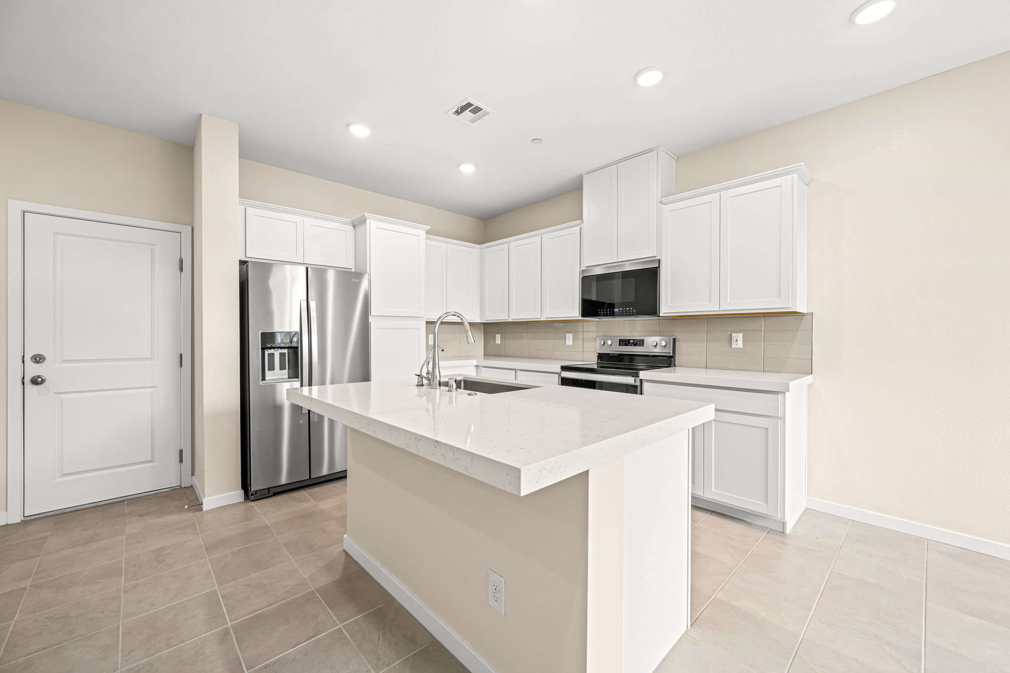 A kitchen with white cabinets.
