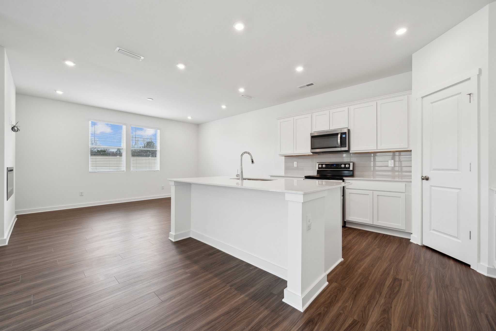 A kitchen with white cabinets.