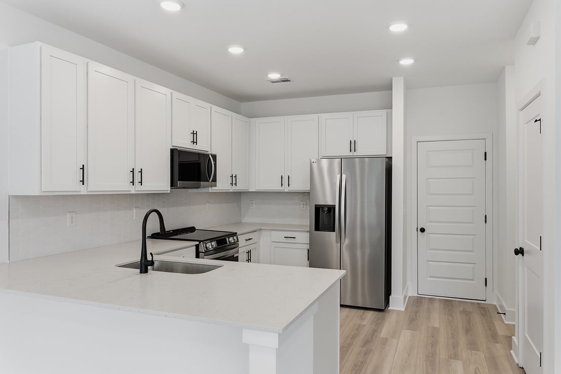 A kitchen with white cabinets.