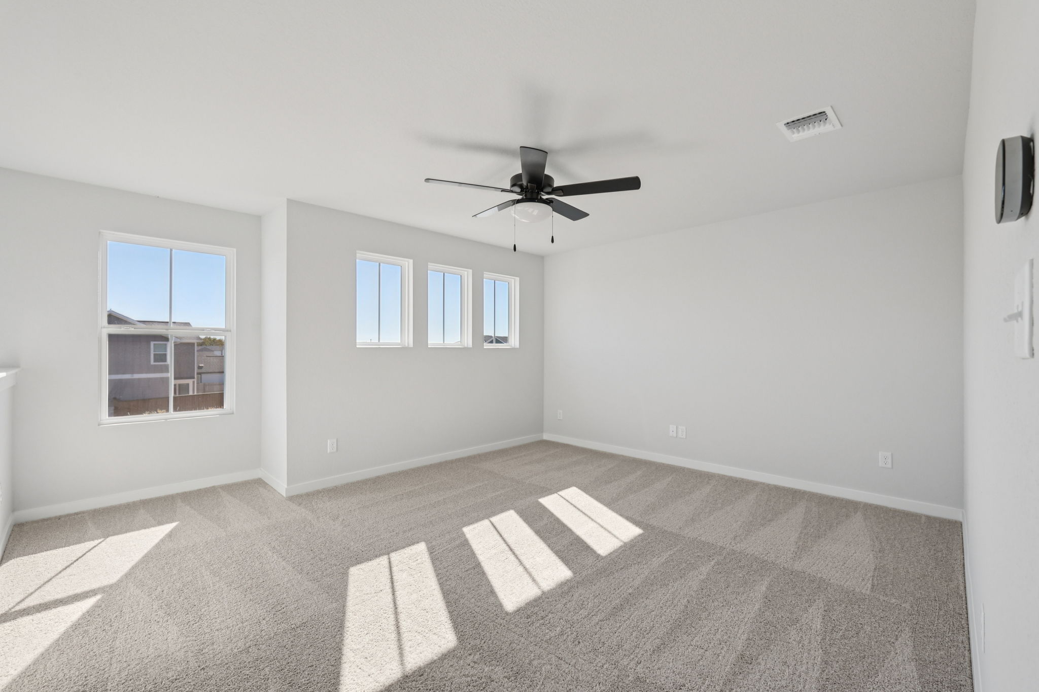 A room with a ceiling fan and a tile floor.