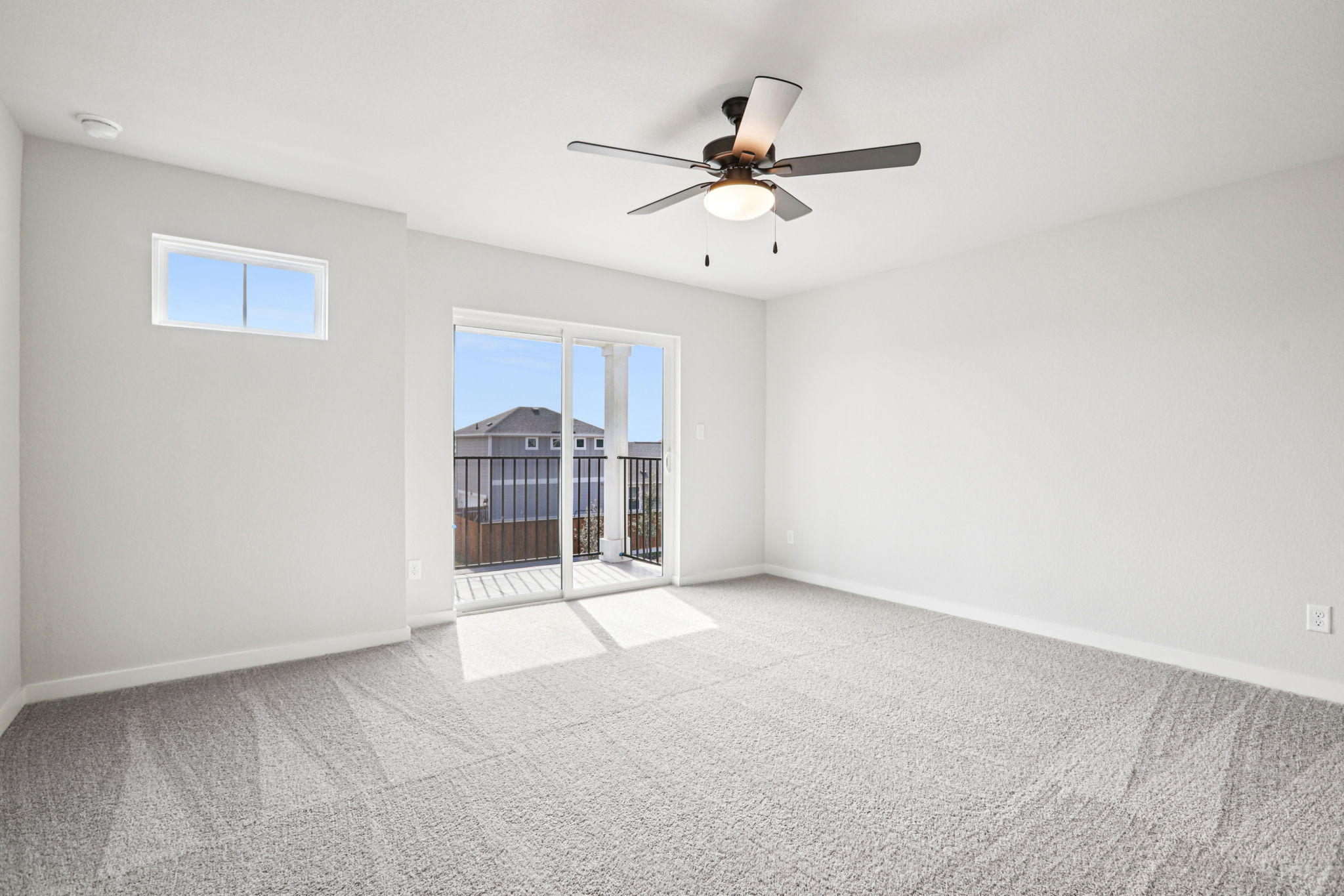 A room with a ceiling fan and a window.