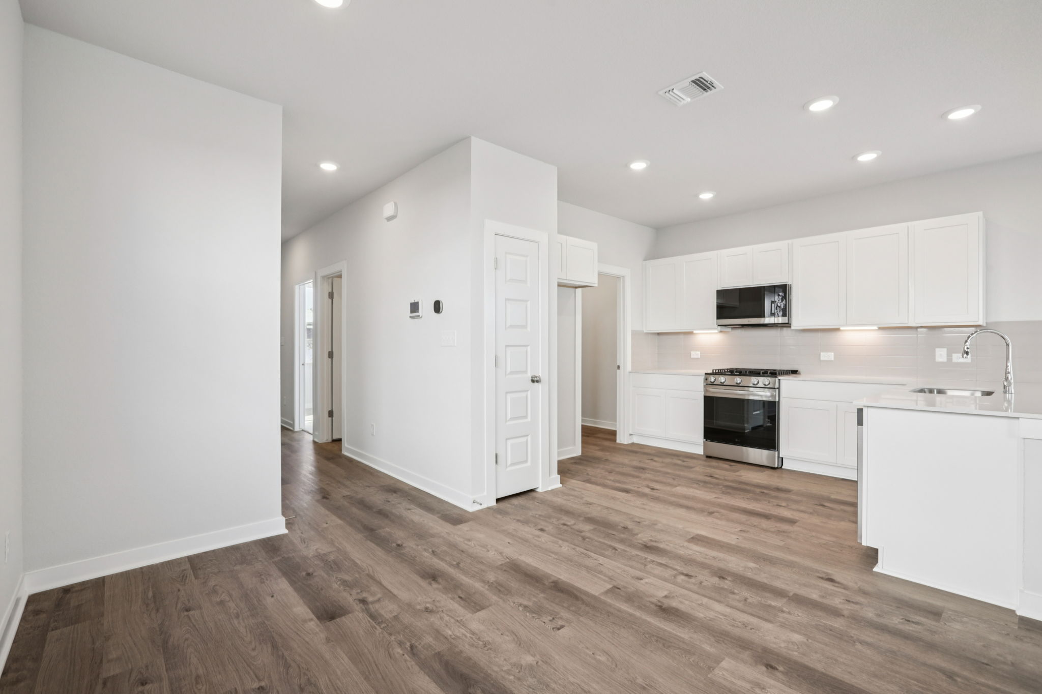 A kitchen with white cabinets.