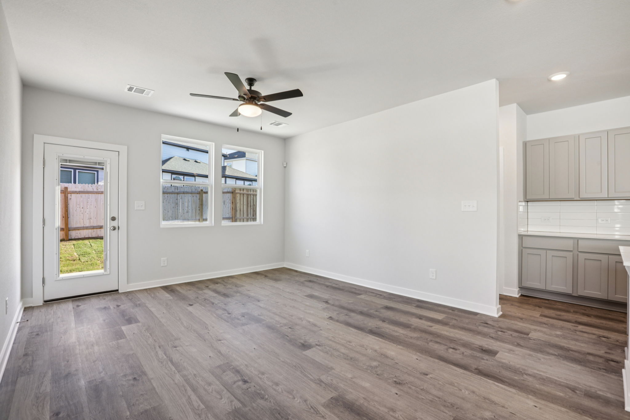 A room with a wood floor and a ceiling fan.