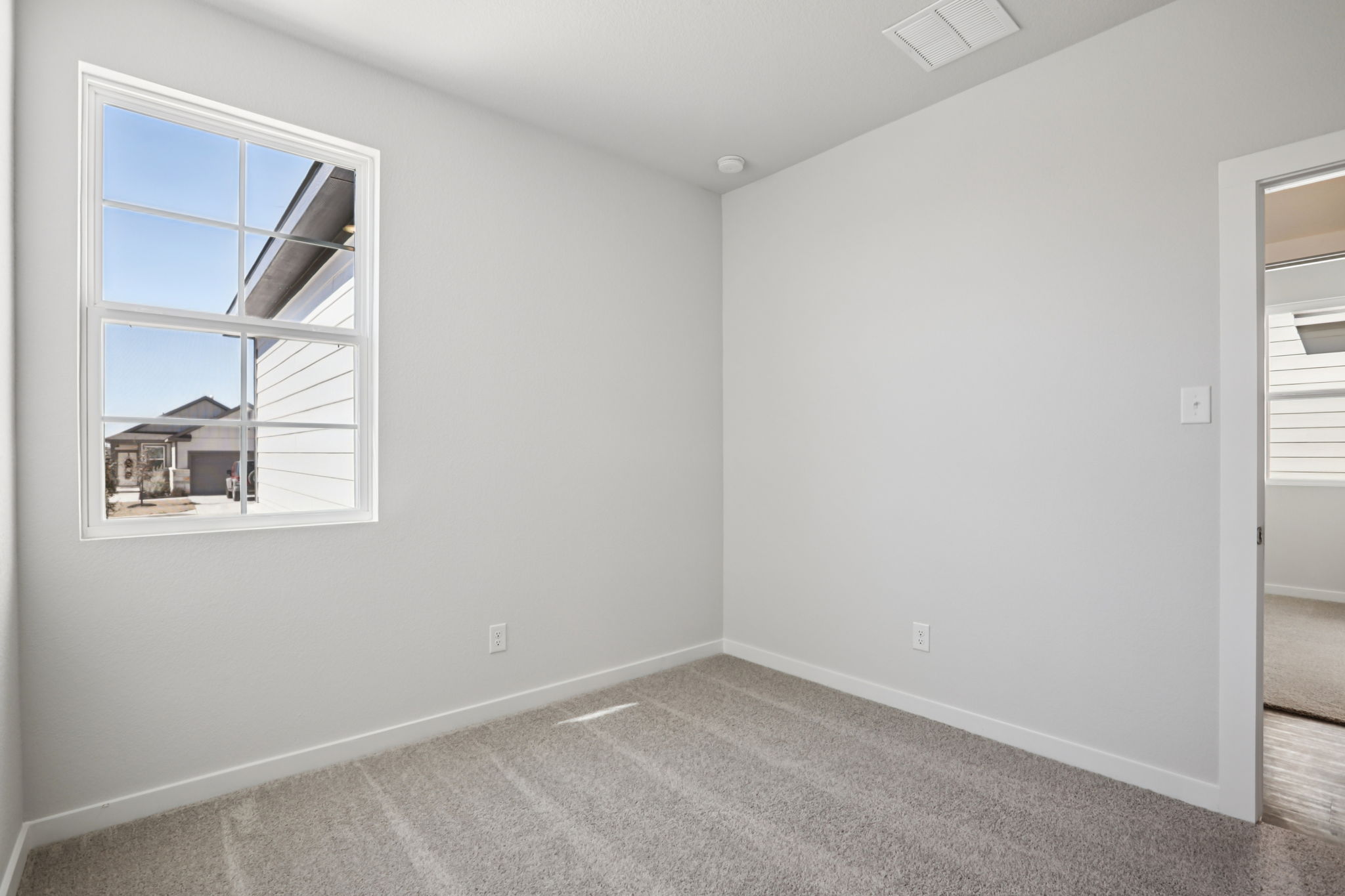 A room with a window and a rug.