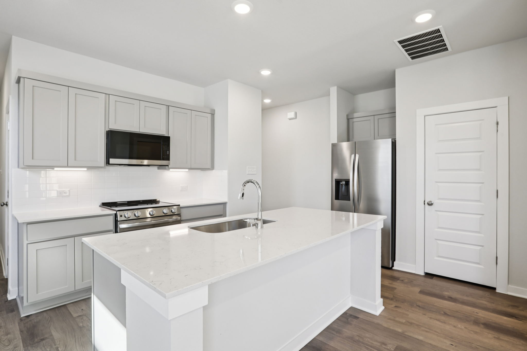 A kitchen with white cabinets.