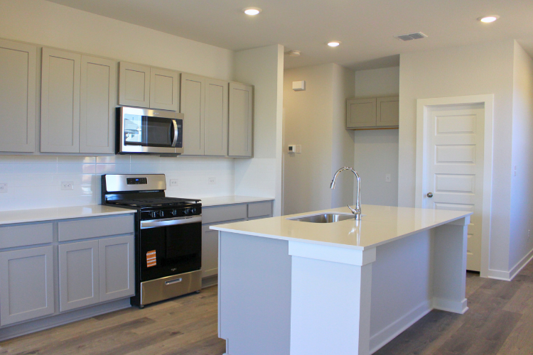A kitchen with white cabinets.