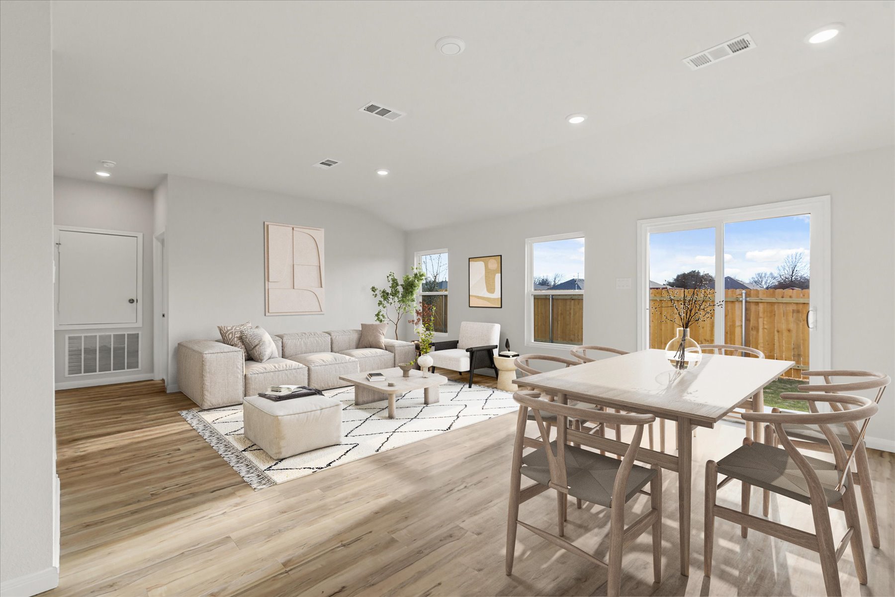 A large living room with a large dining table and a large window.
