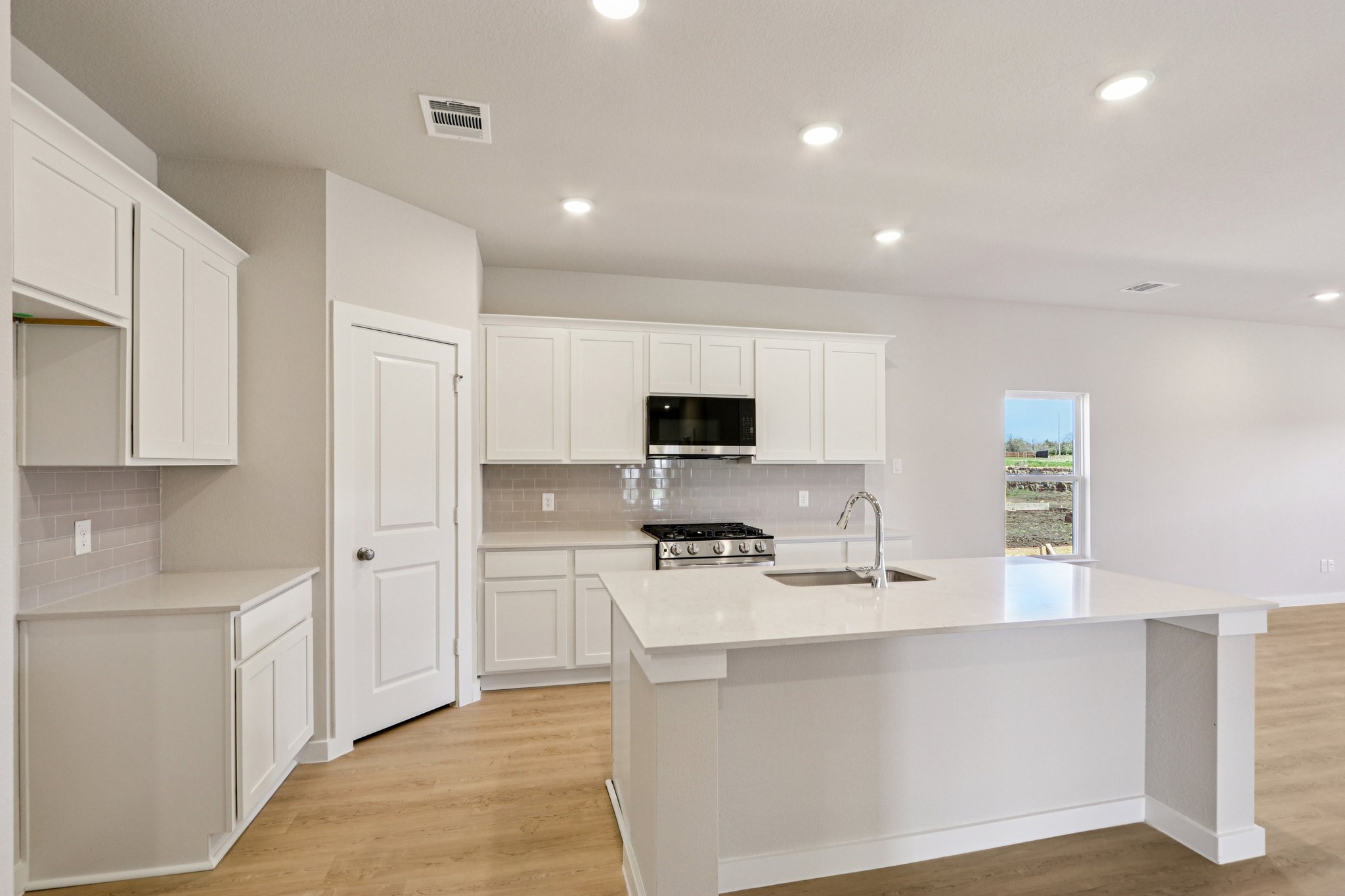A kitchen with white cabinets.
