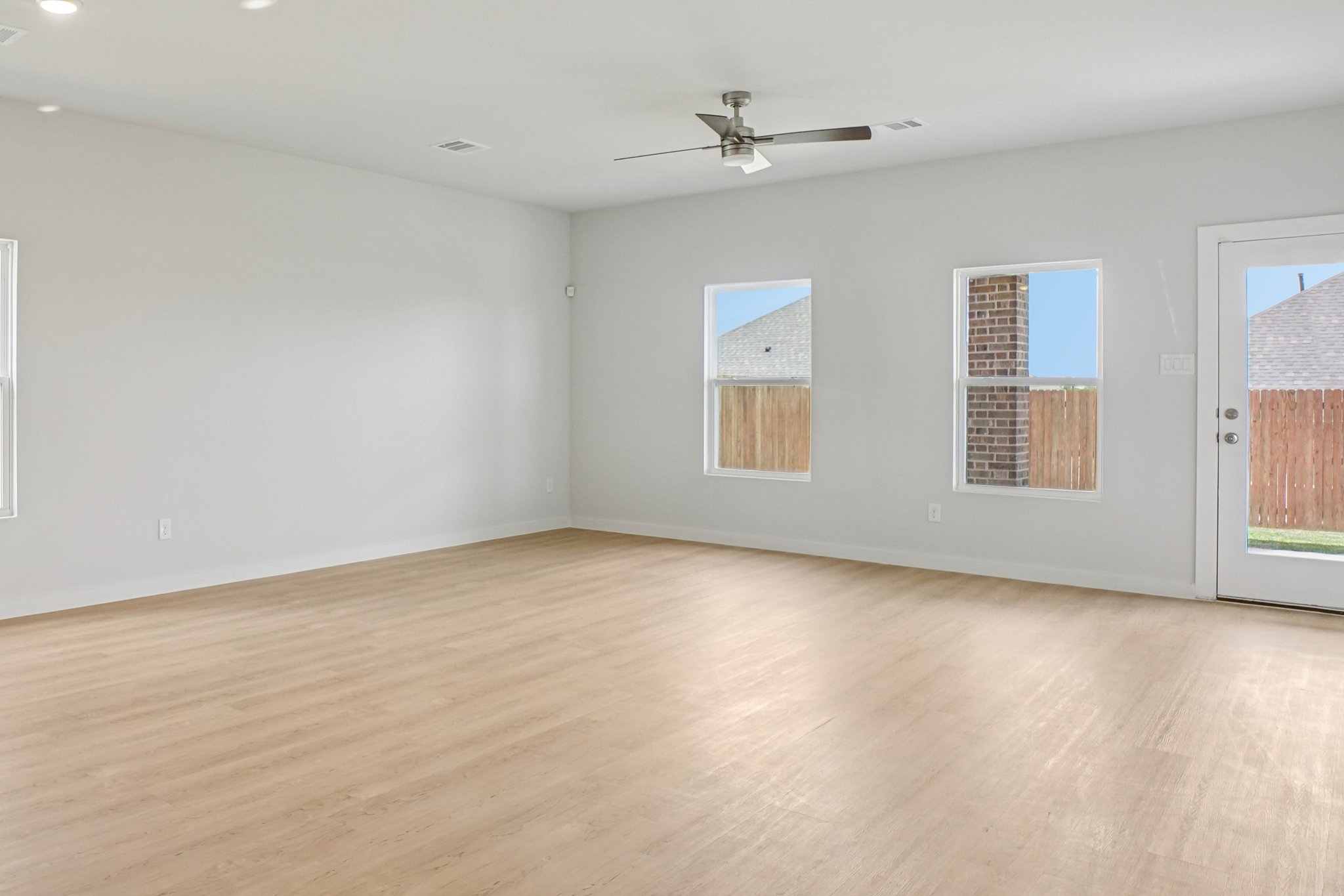 A room with a wood floor and a ceiling fan.