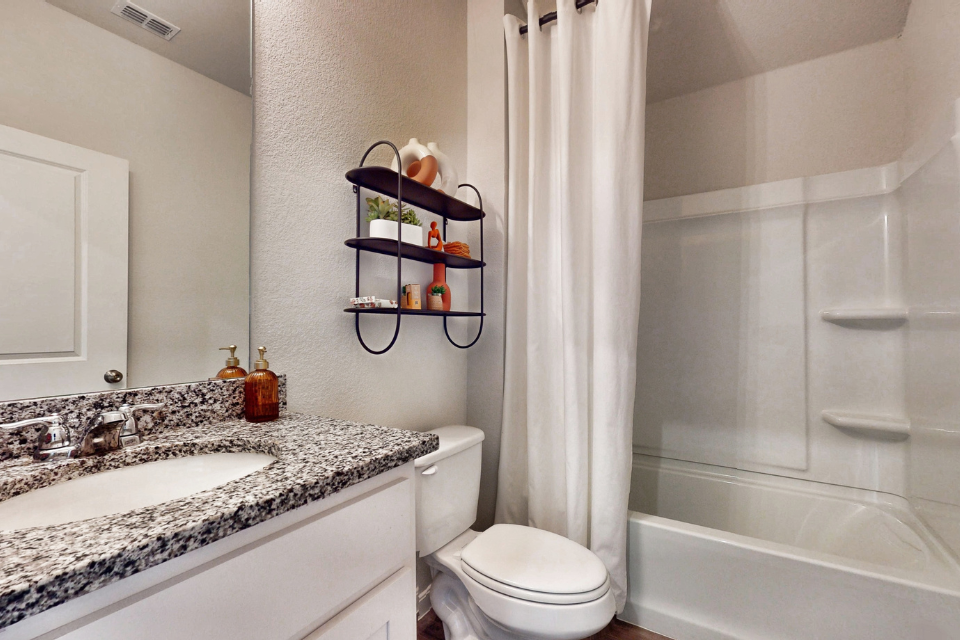 A bathroom with a sink toilet and shower.