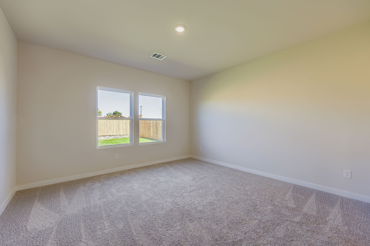 A room with a carpet and windows.