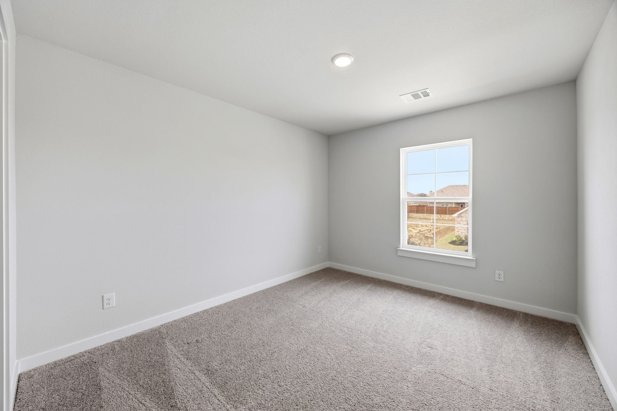 A room with a window and a carpet.