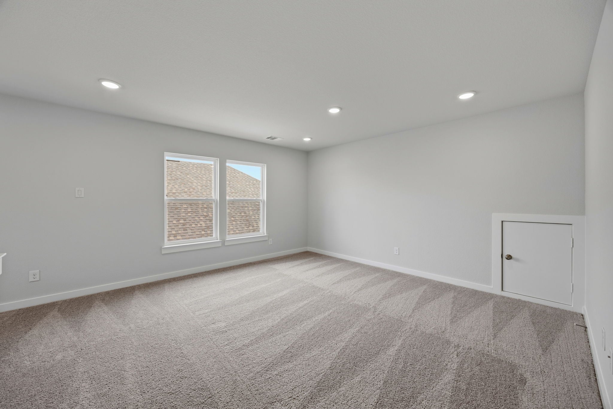 A room with a carpet and a door.