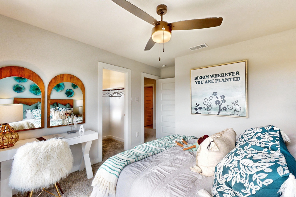 A bedroom with a fan and a bed.