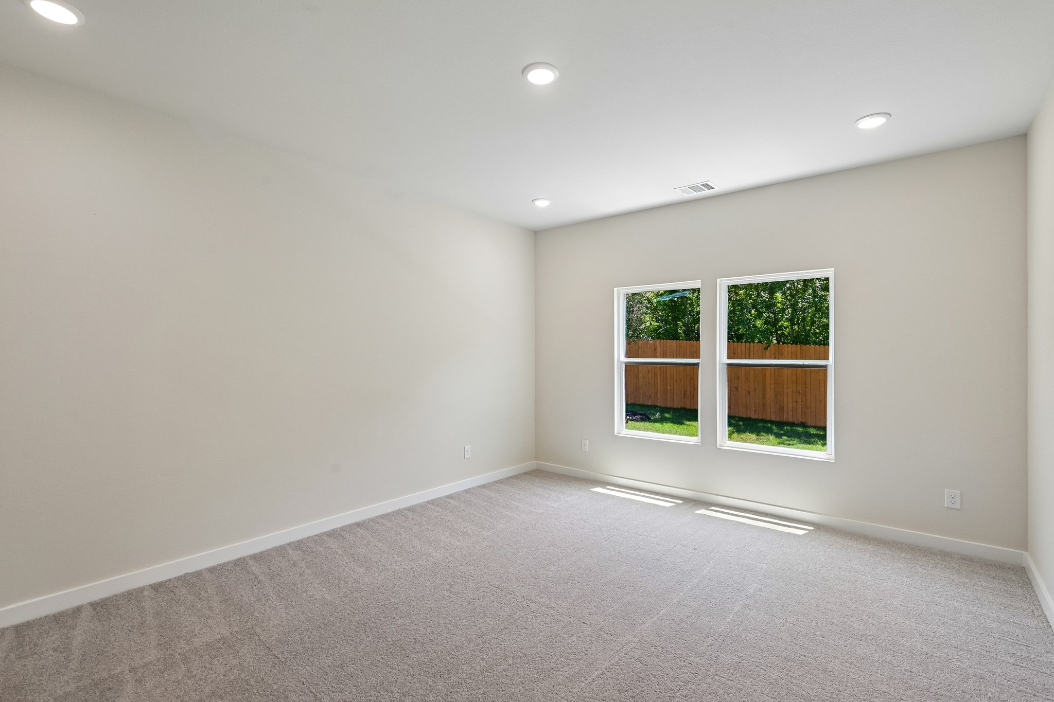 A room with windows and a carpet.
