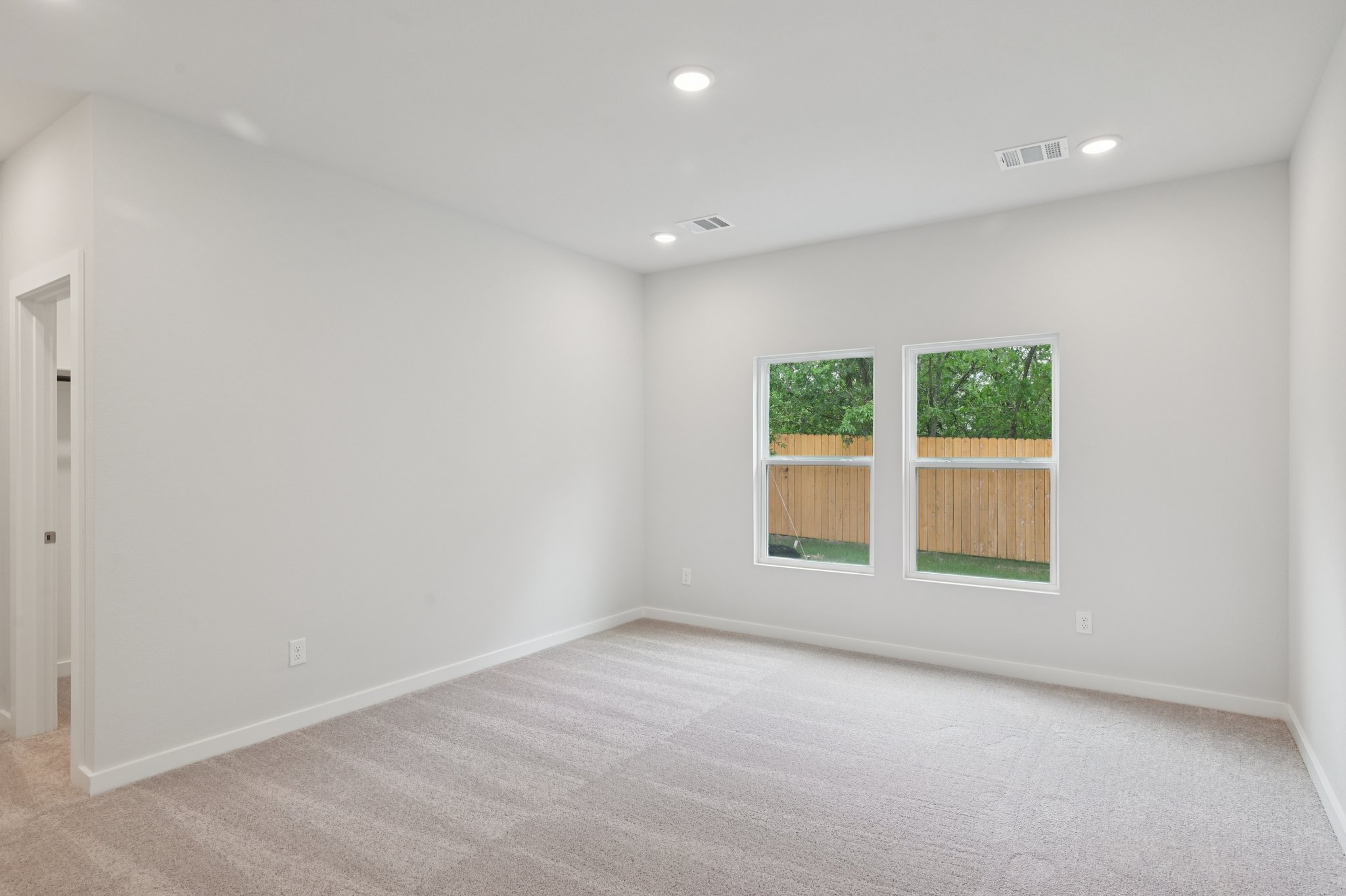 A room with windows and a carpet.
