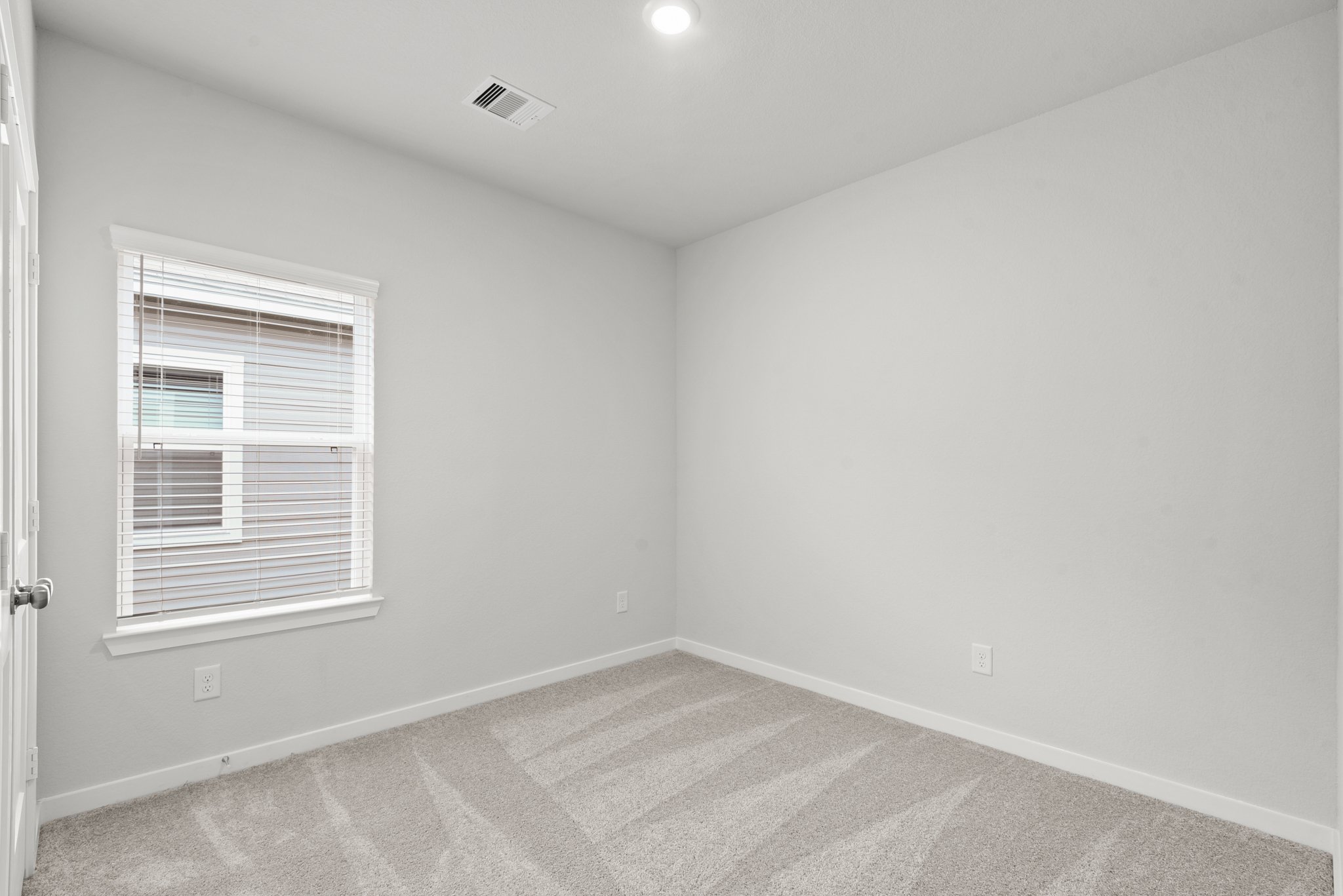 A room with a window and a rug.