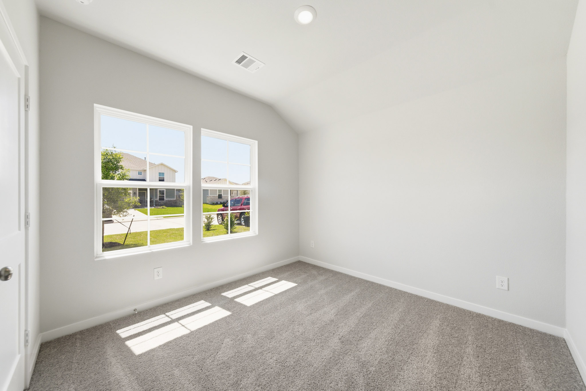 A room with a window and a carpet.