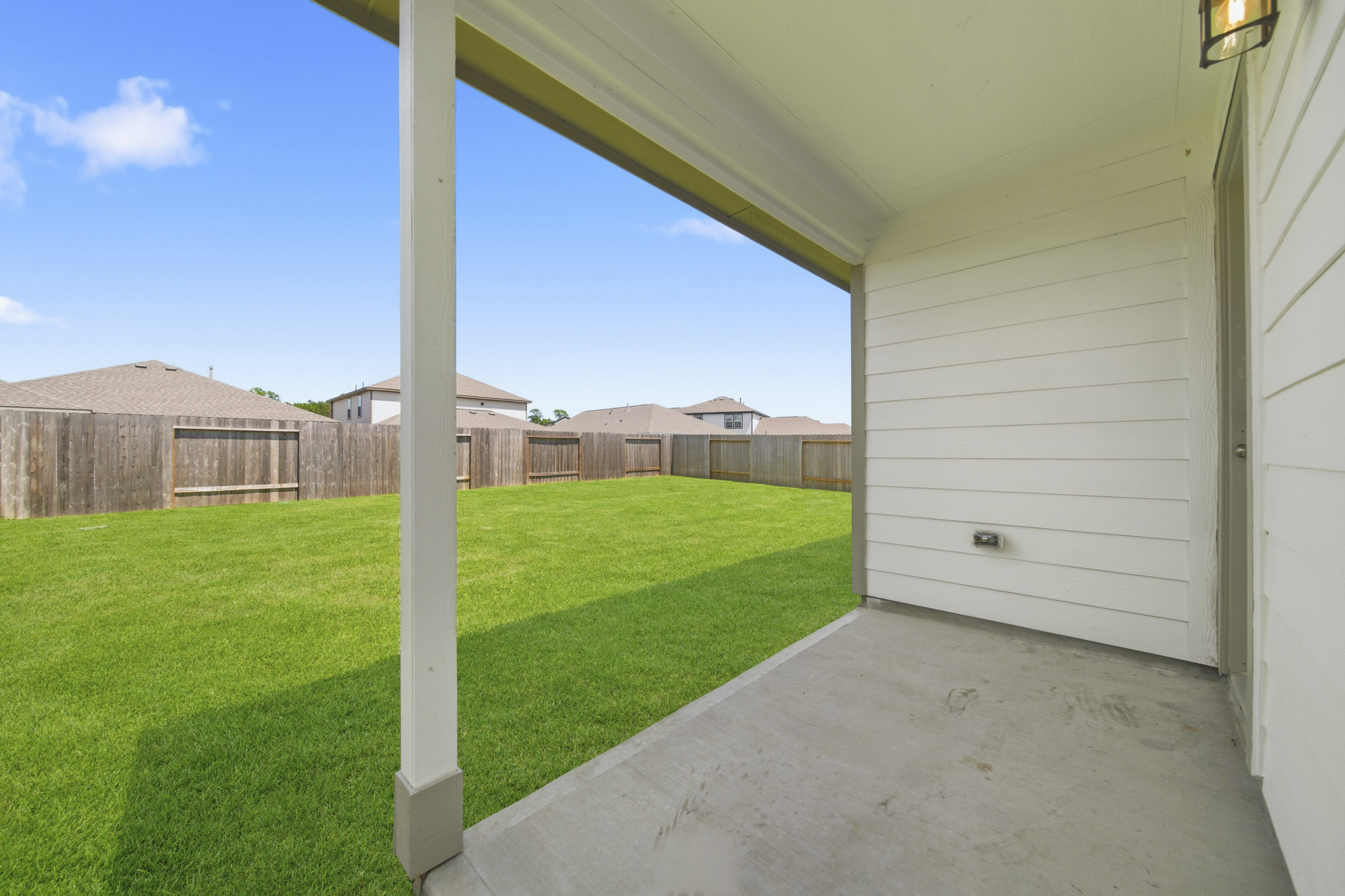 A backyard with a fence and a house.