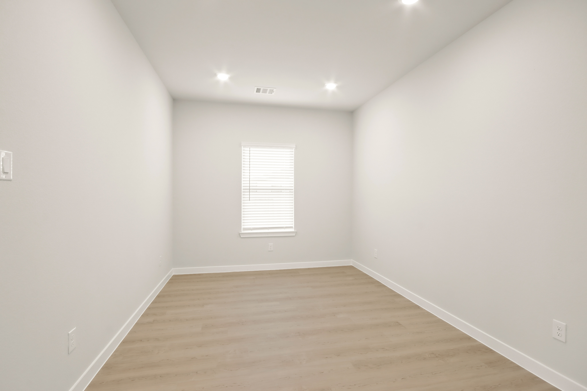A room with a wood floor and white walls.