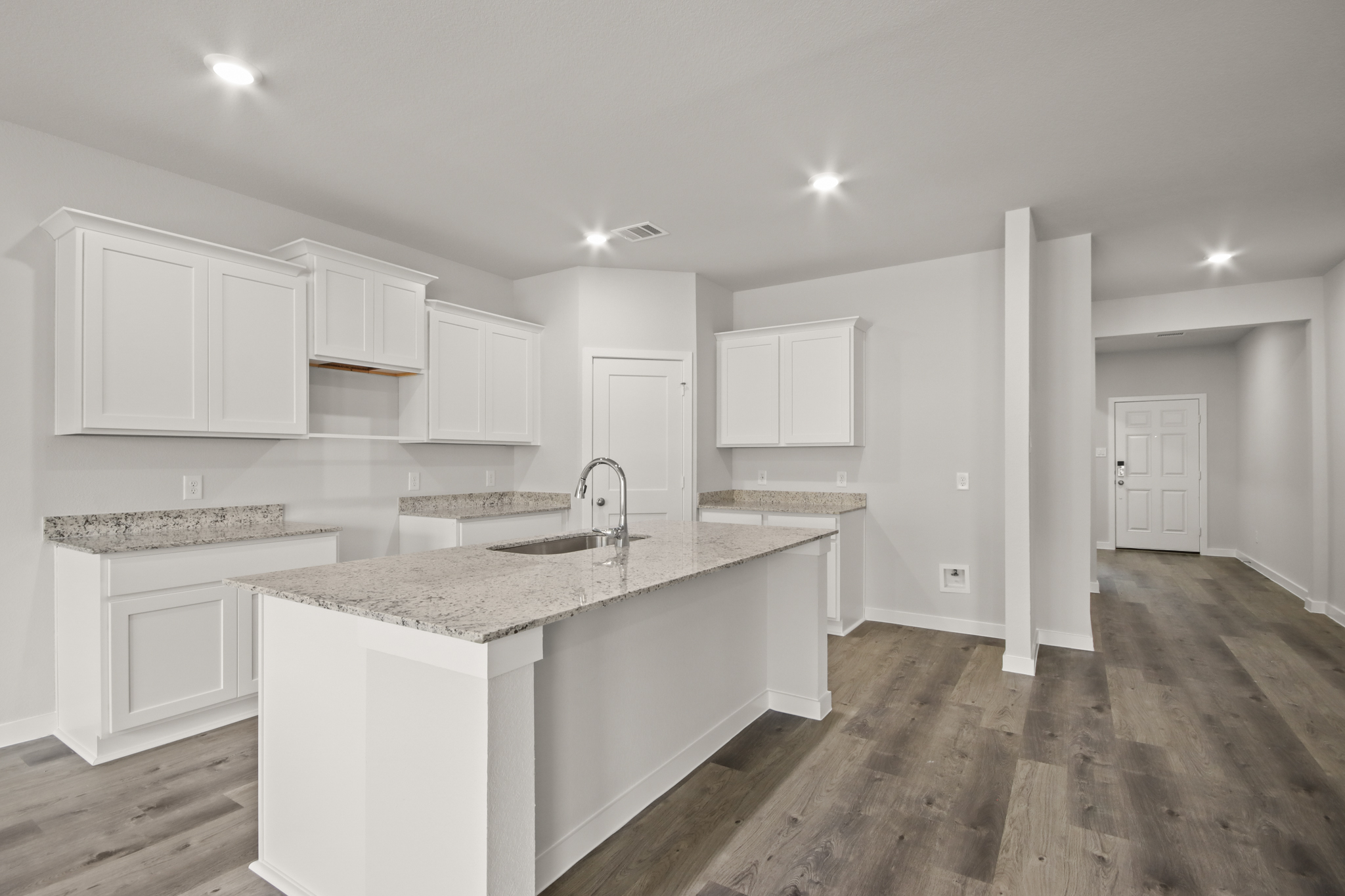 A kitchen with white cabinets.