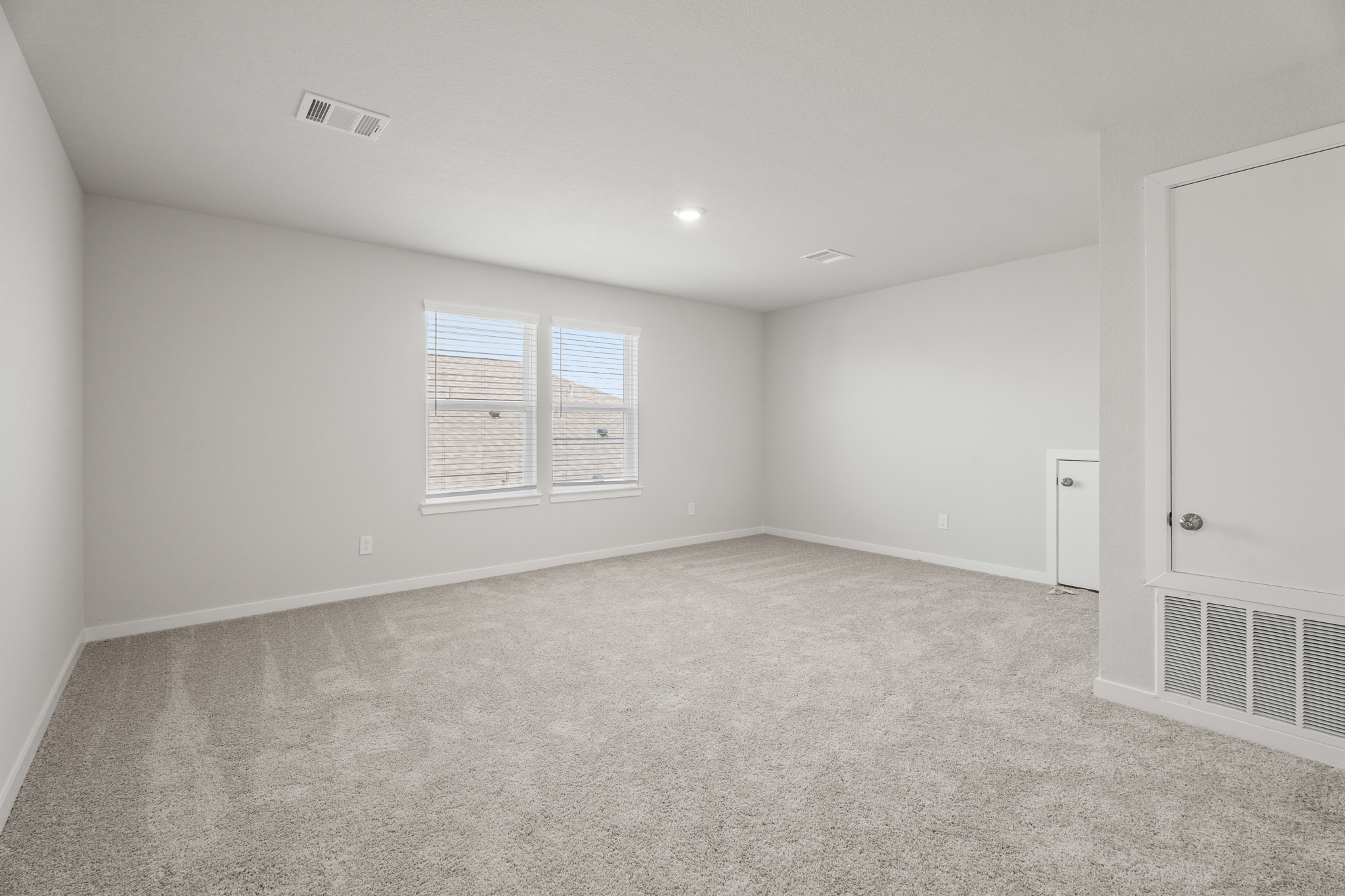 A room with a carpet and a door.