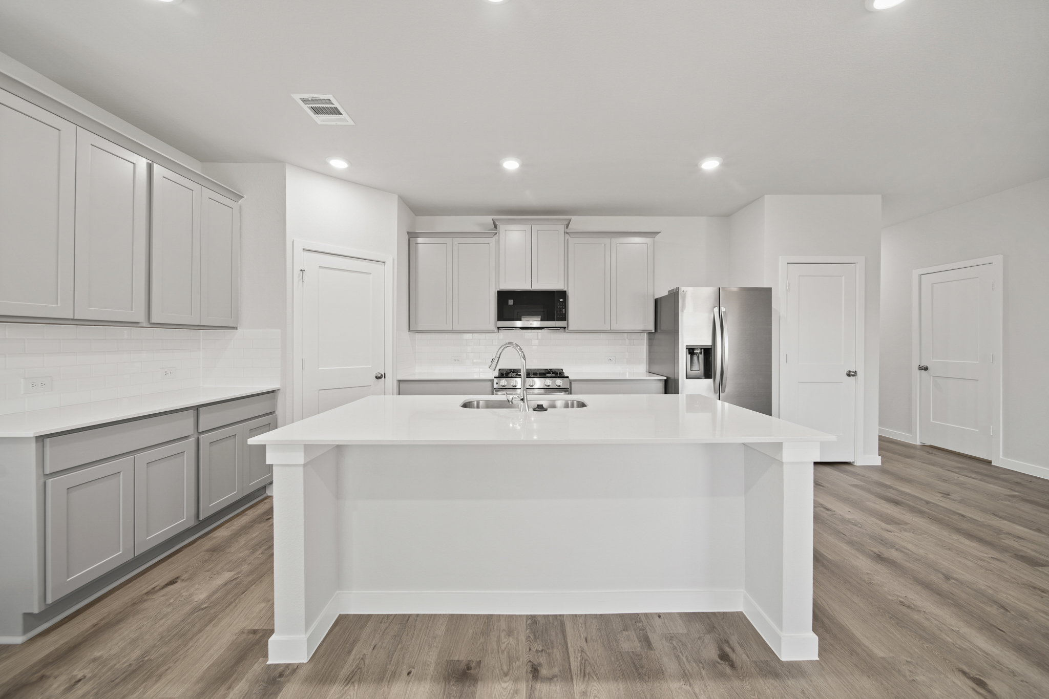 A kitchen with white cabinets.