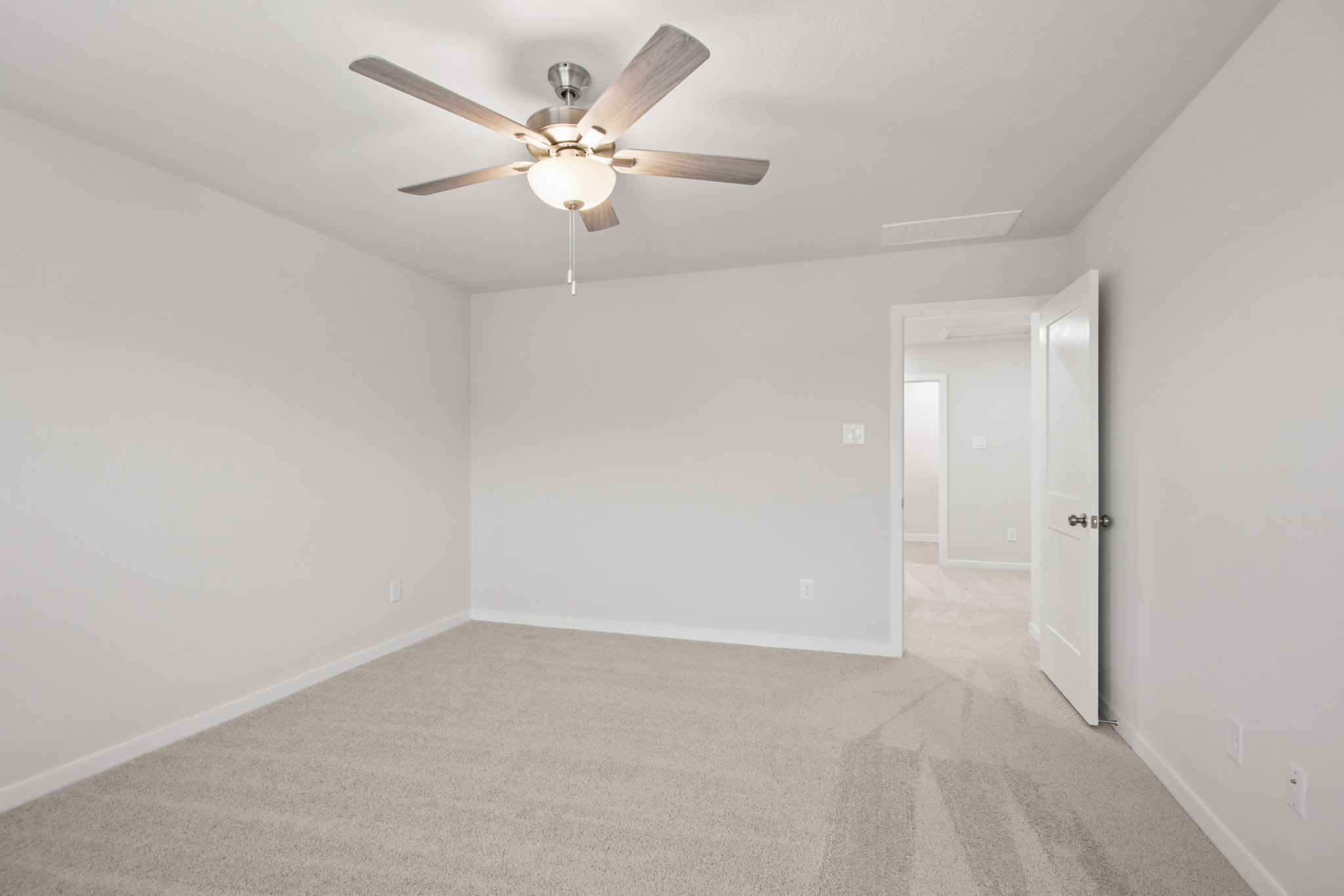 A room with a ceiling fan and a door.