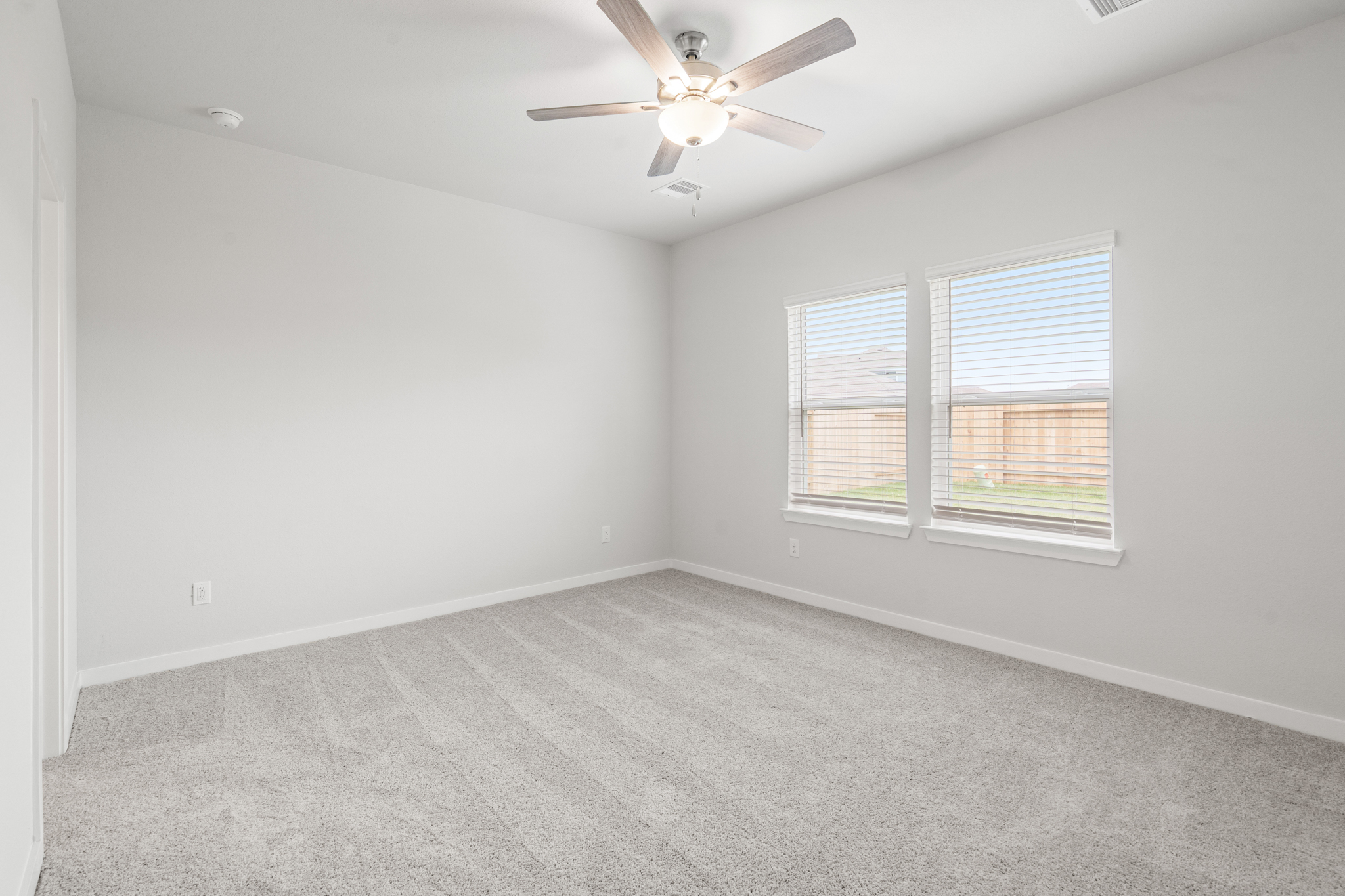 A room with a ceiling fan and a window.
