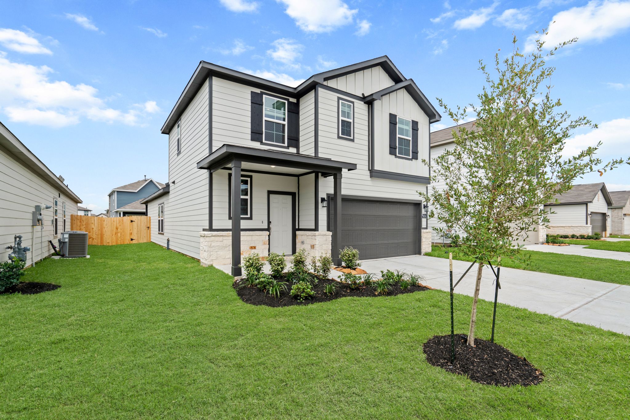 A house with a tree in the front yard.
