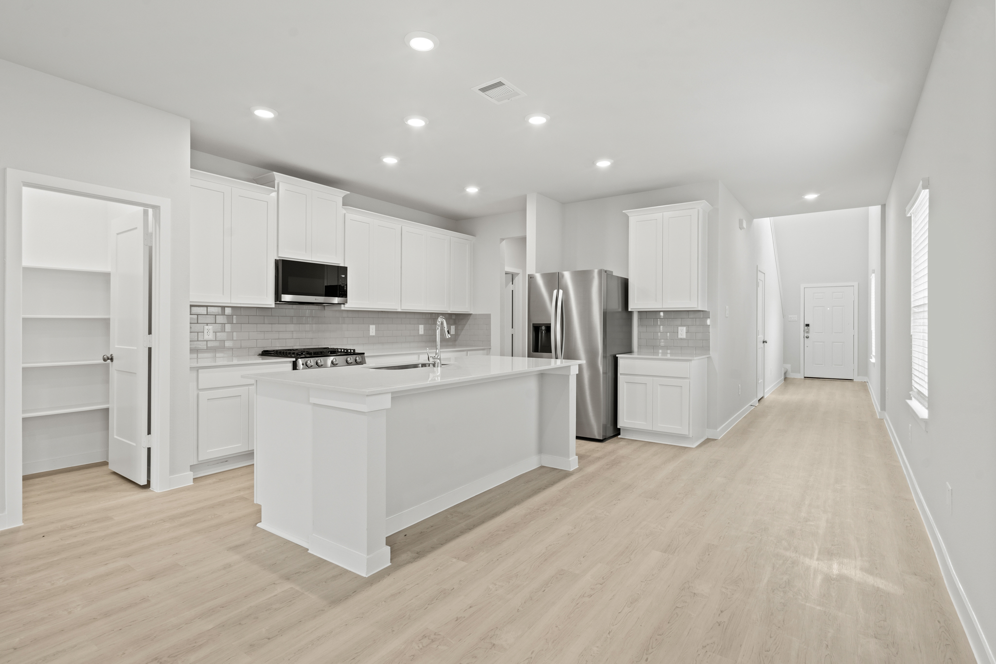 A kitchen with white cabinets.