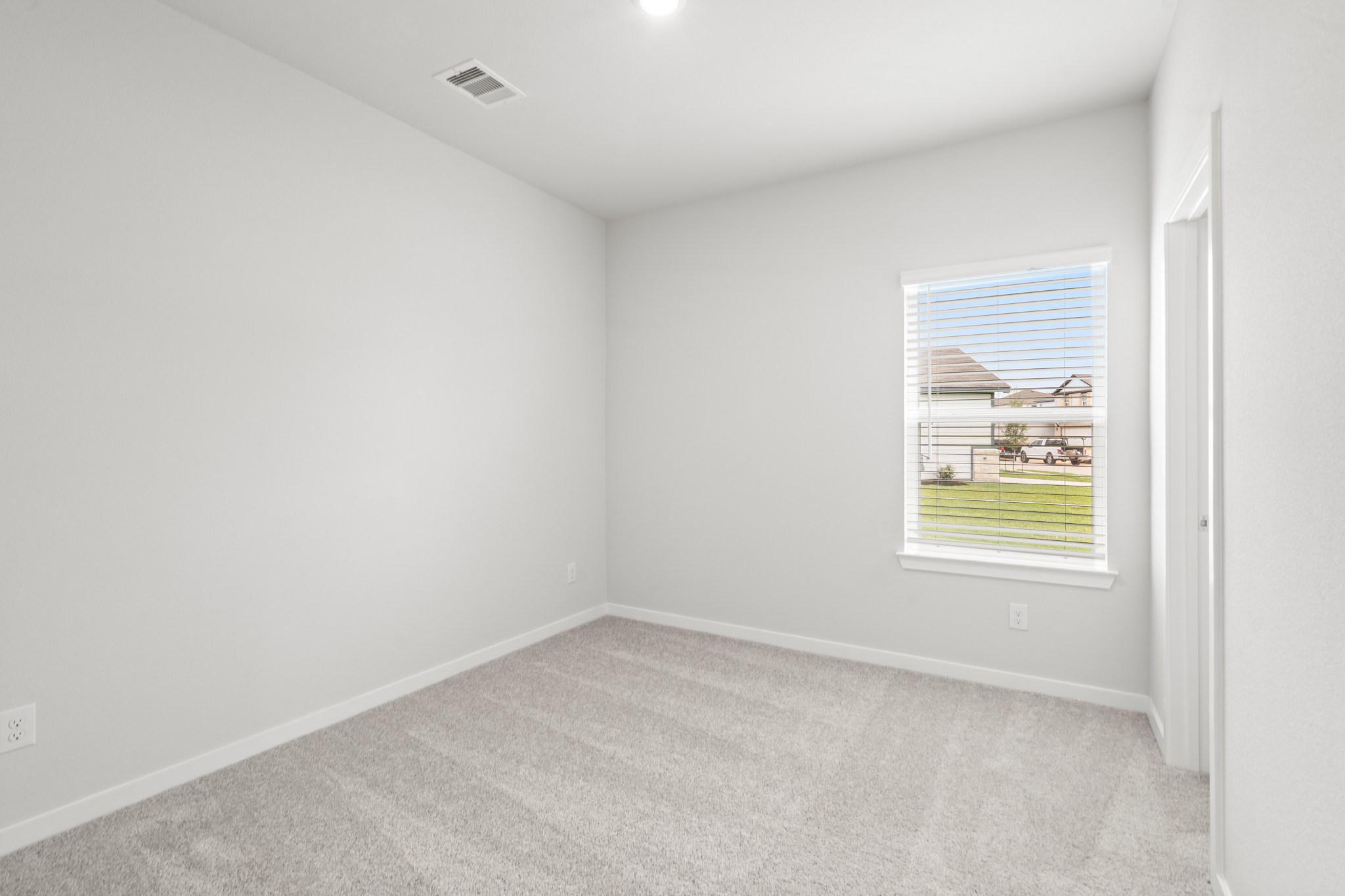 A room with a window and a carpet.