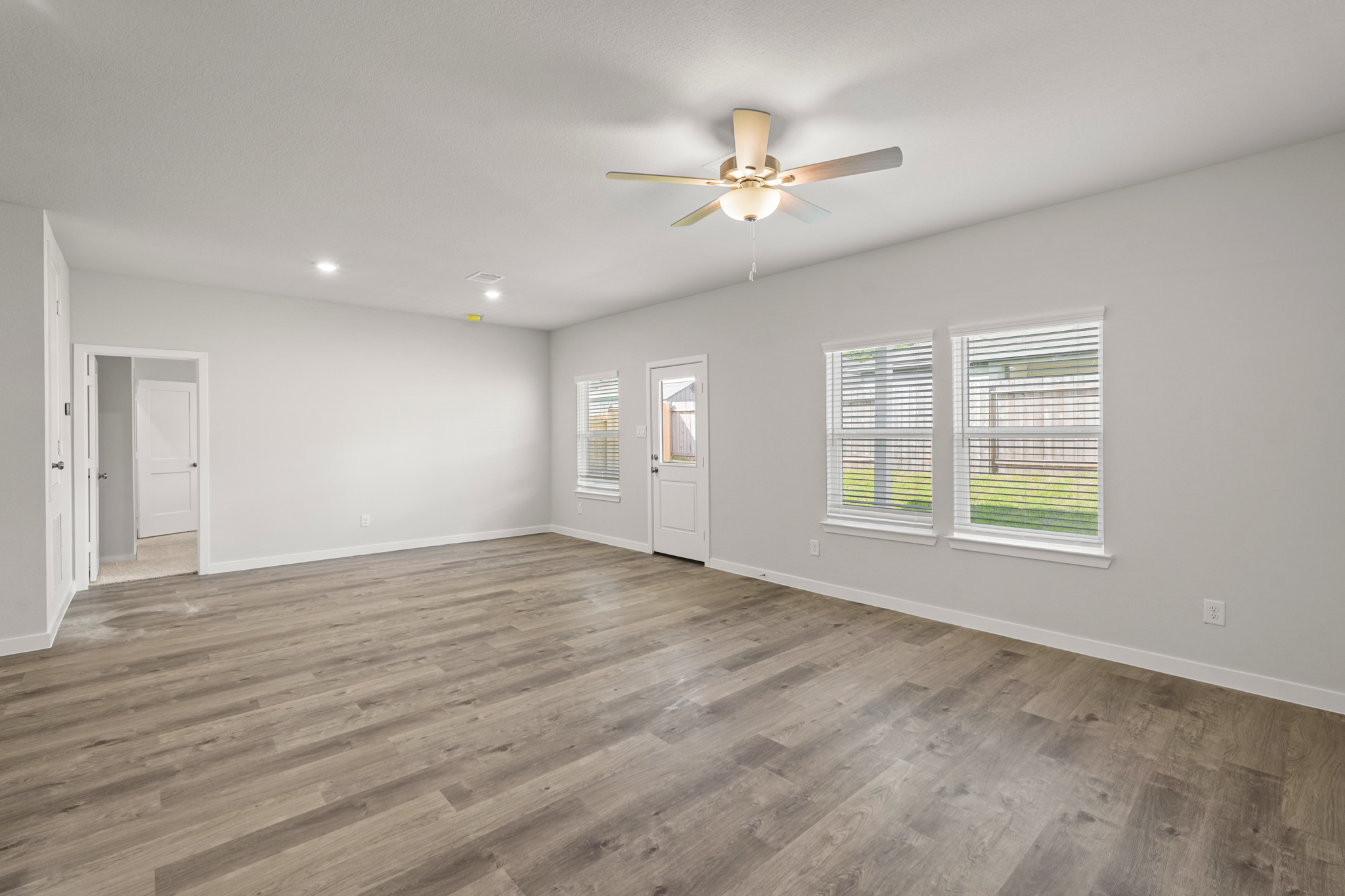 A room with a wood floor and a ceiling fan.