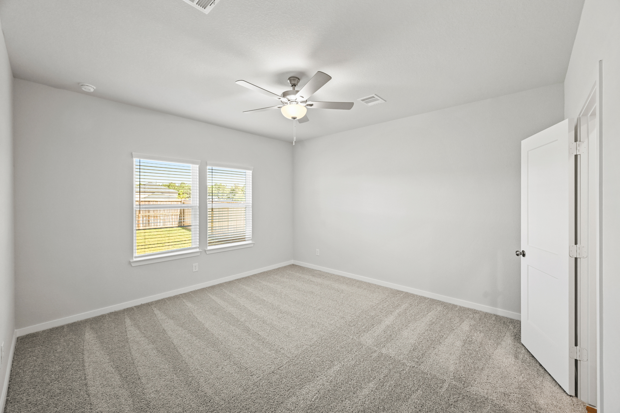 A room with a ceiling fan and a window.