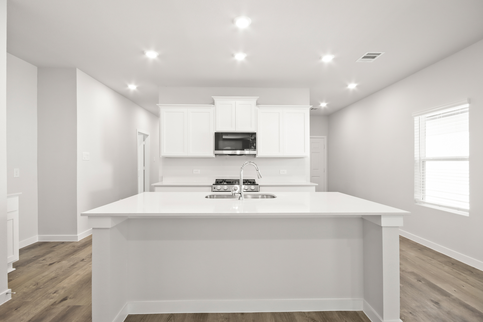 A kitchen with white cabinets.