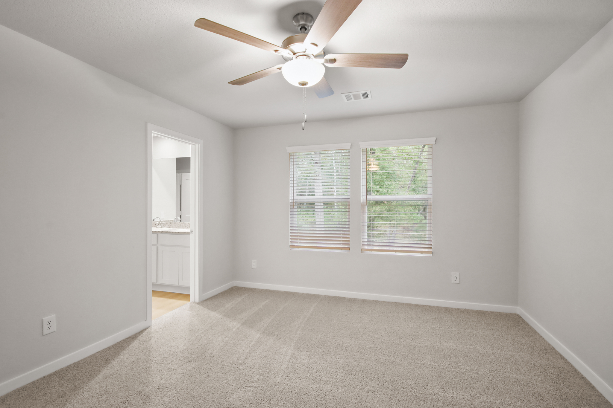 A room with a ceiling fan and a window.