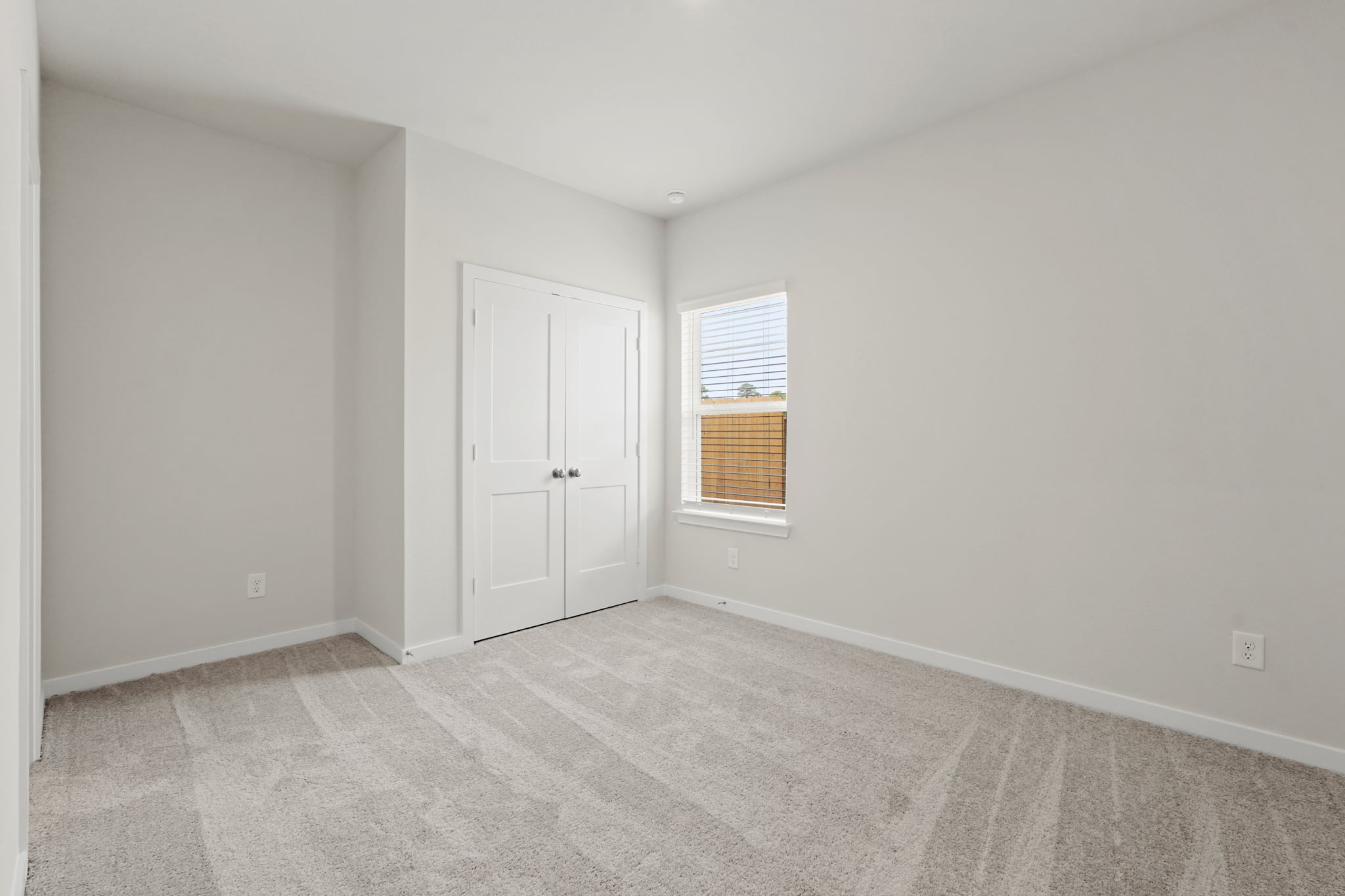 A room with white walls and a window.