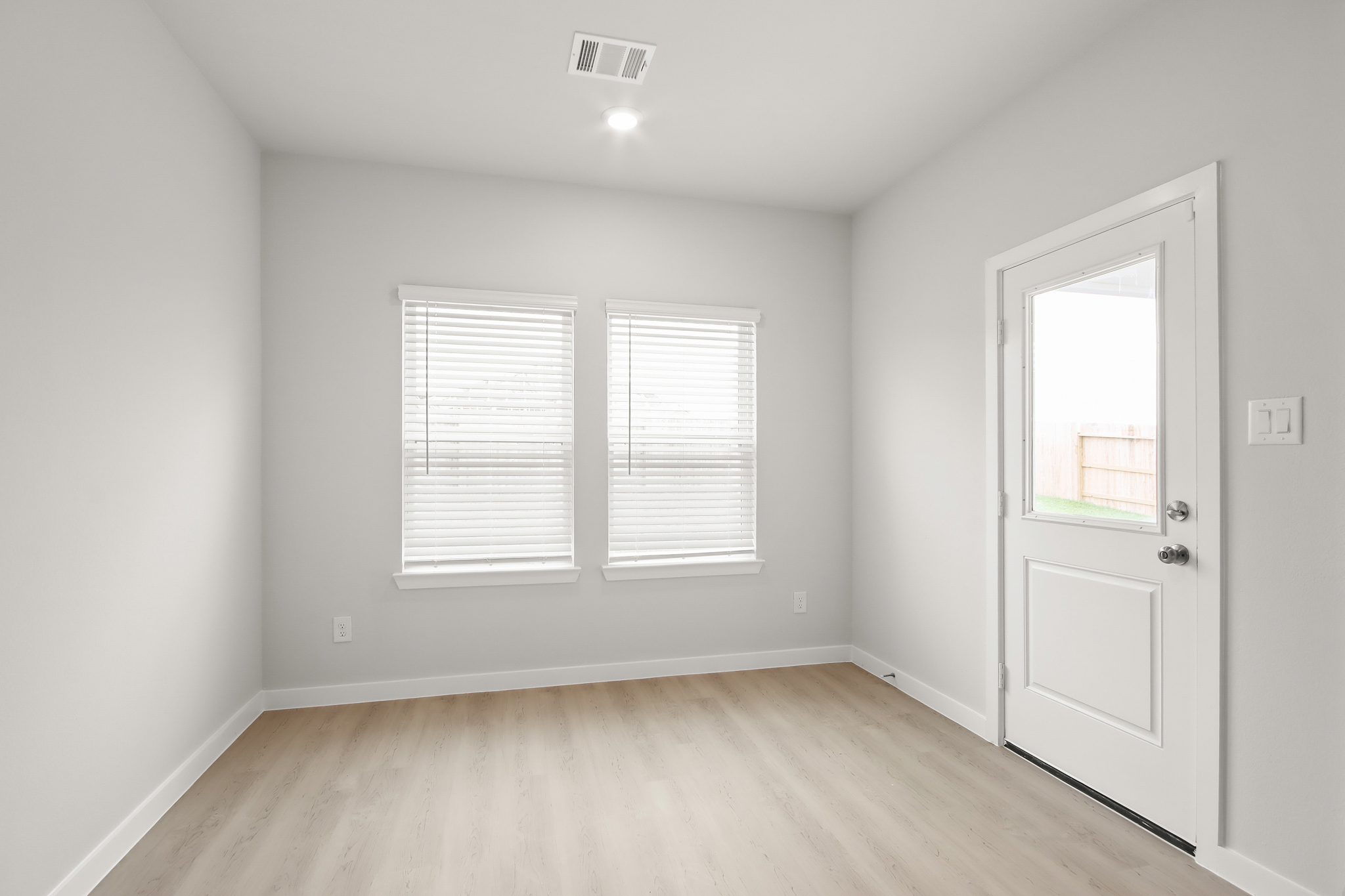 A room with white walls and a wood floor.