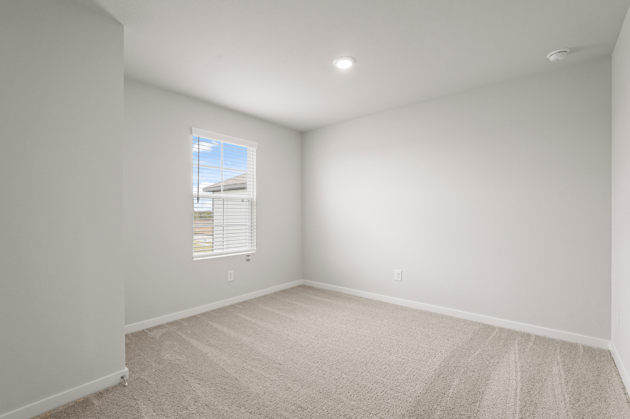 A room with a window and a carpet.