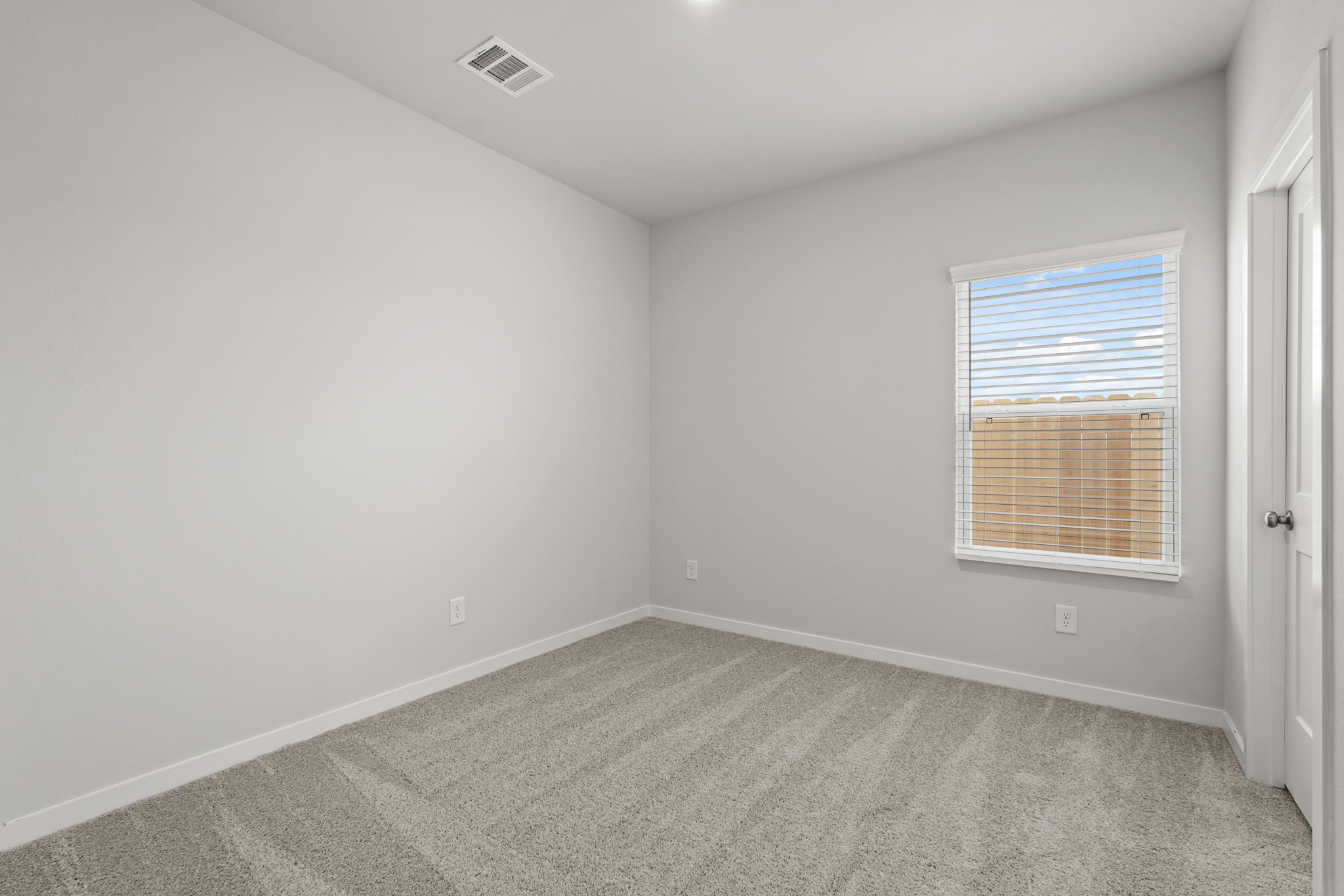 A room with a window and a carpet.