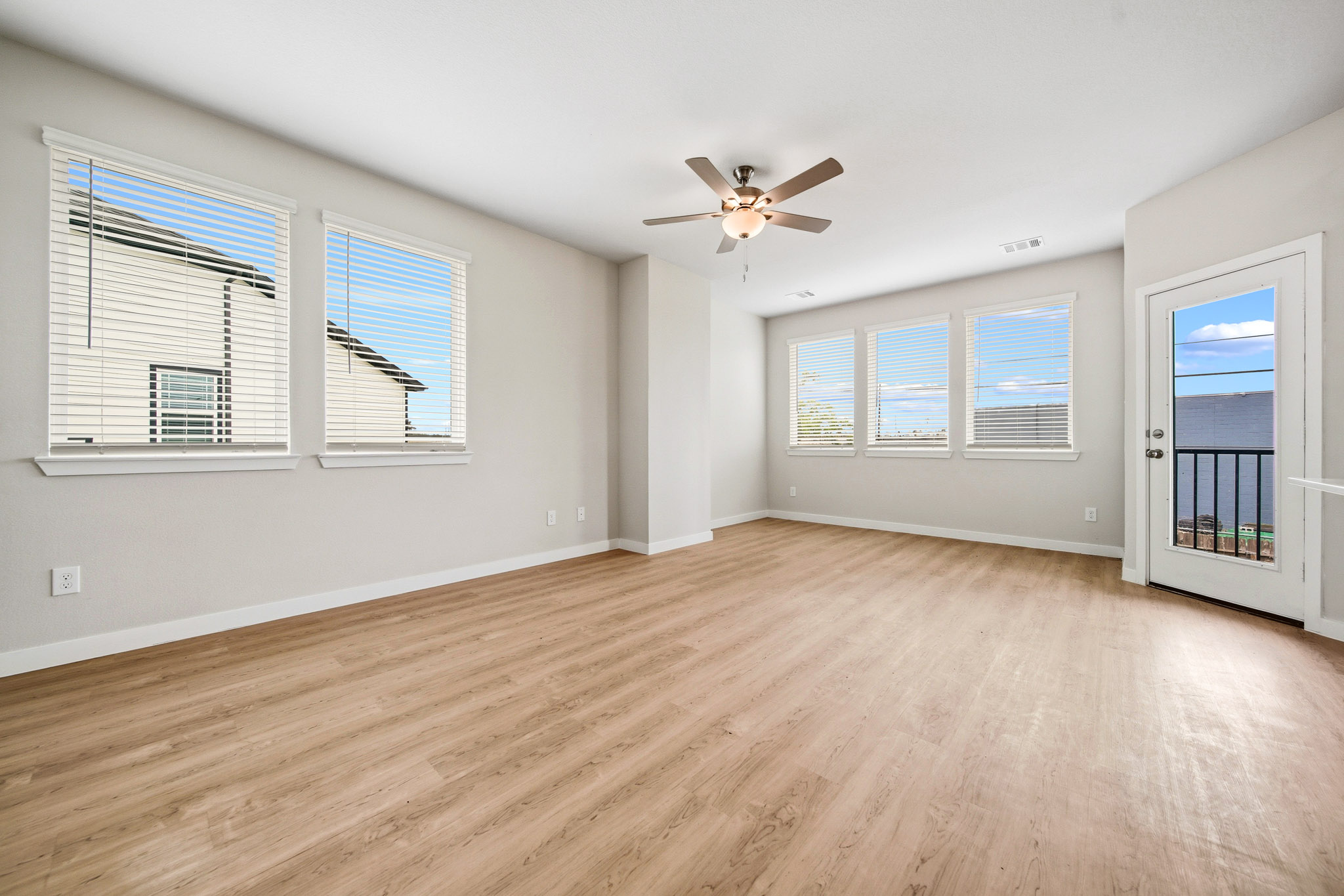 A room with a wood floor and a ceiling fan.
