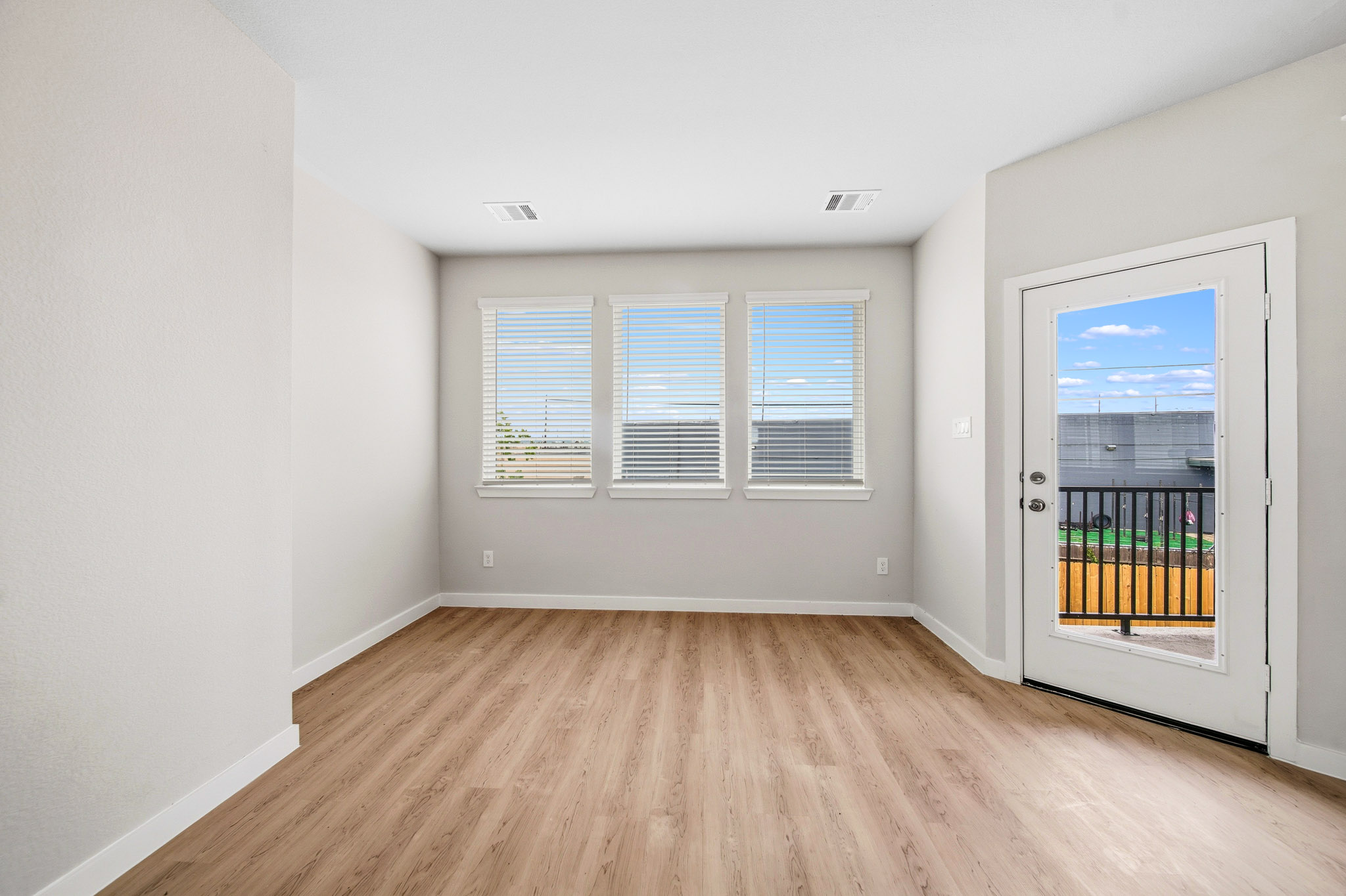 A room with a wood floor and a door with a window.