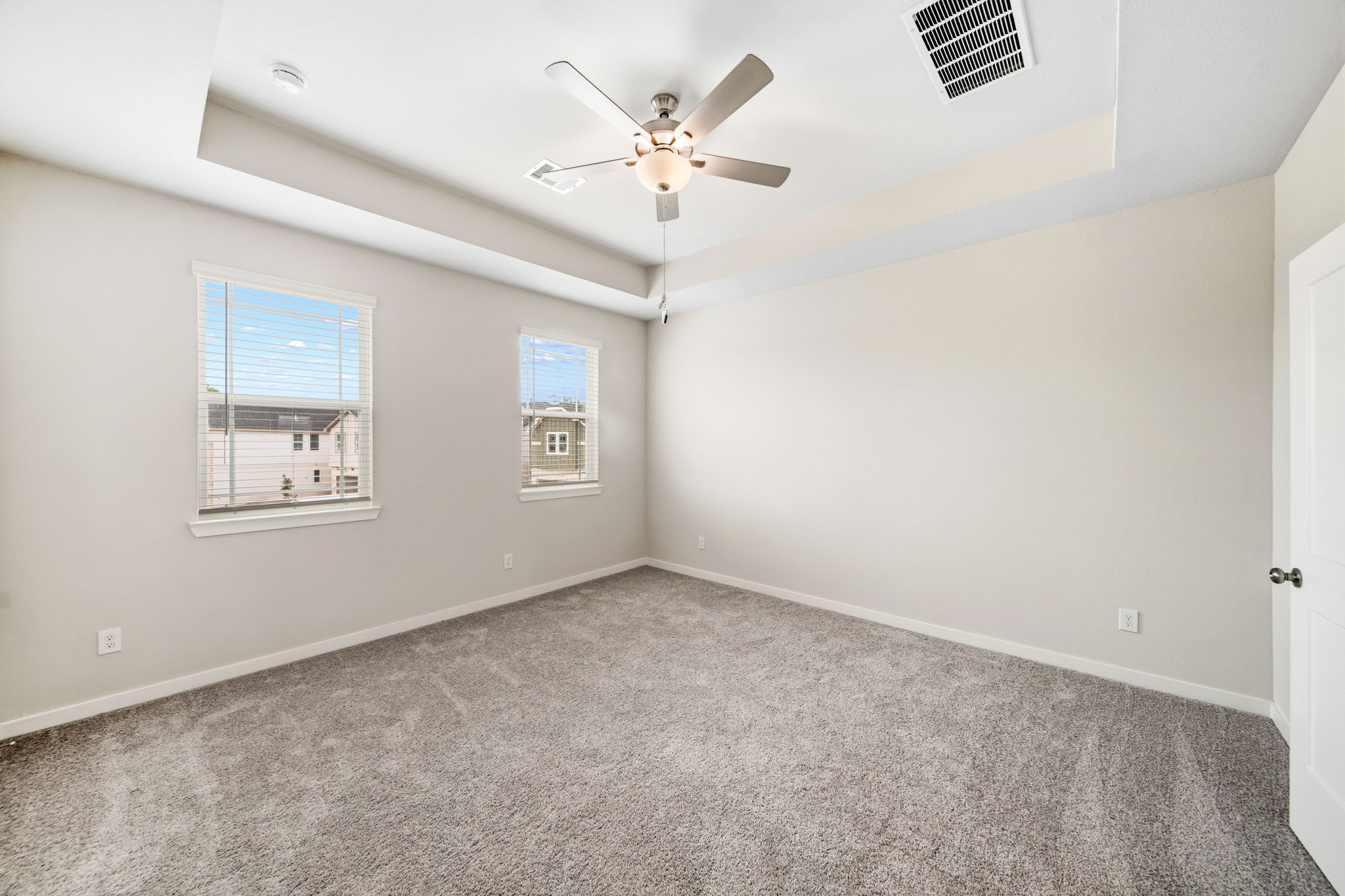 A room with a ceiling fan and a window.