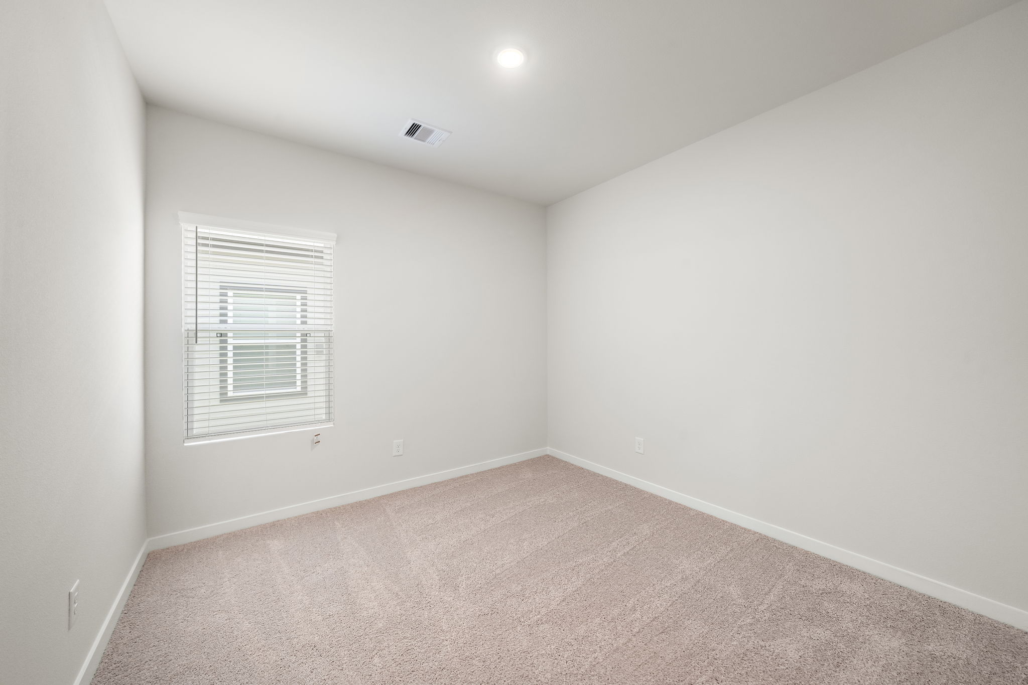 A room with a carpet and a window.