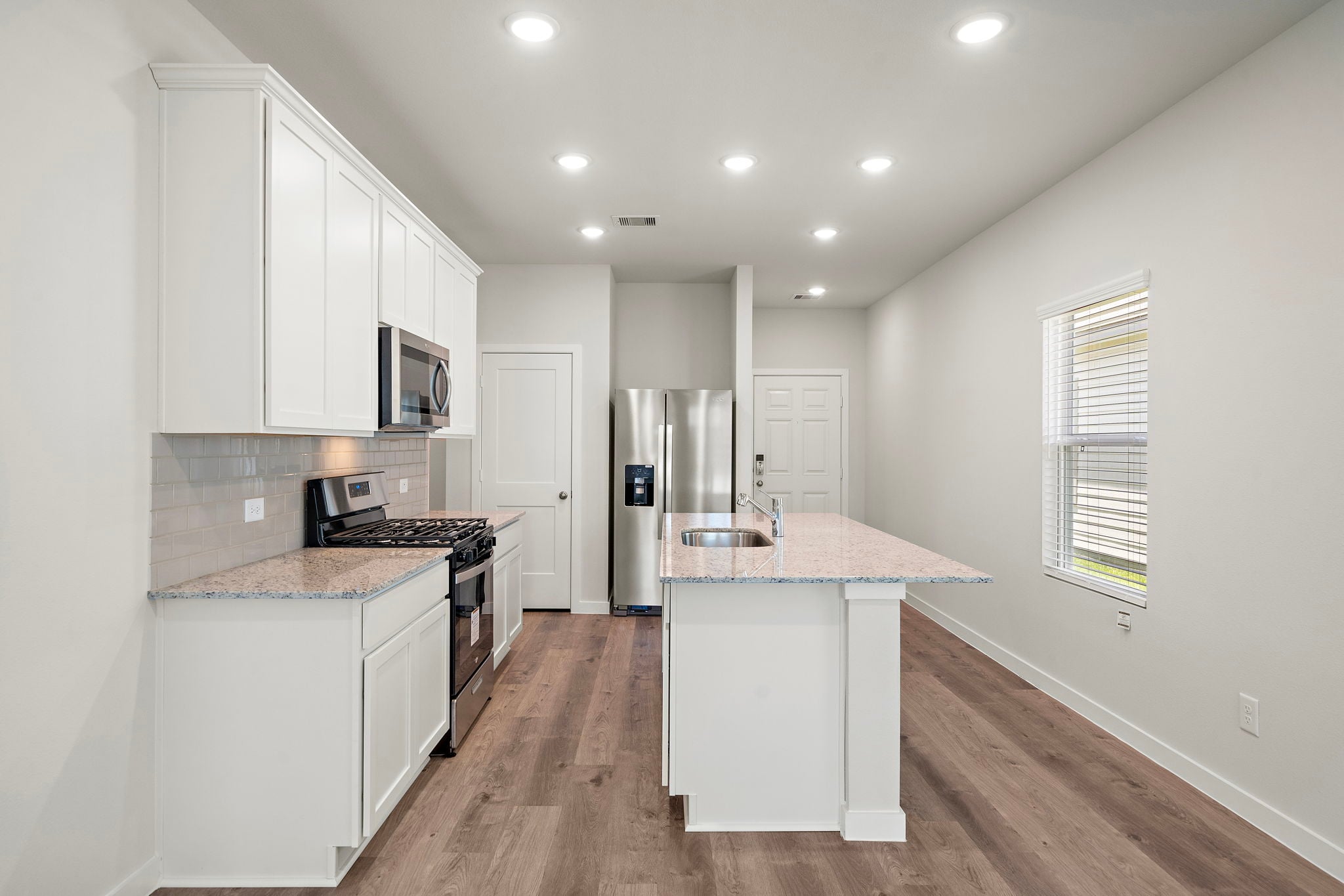 A kitchen with white cabinets.