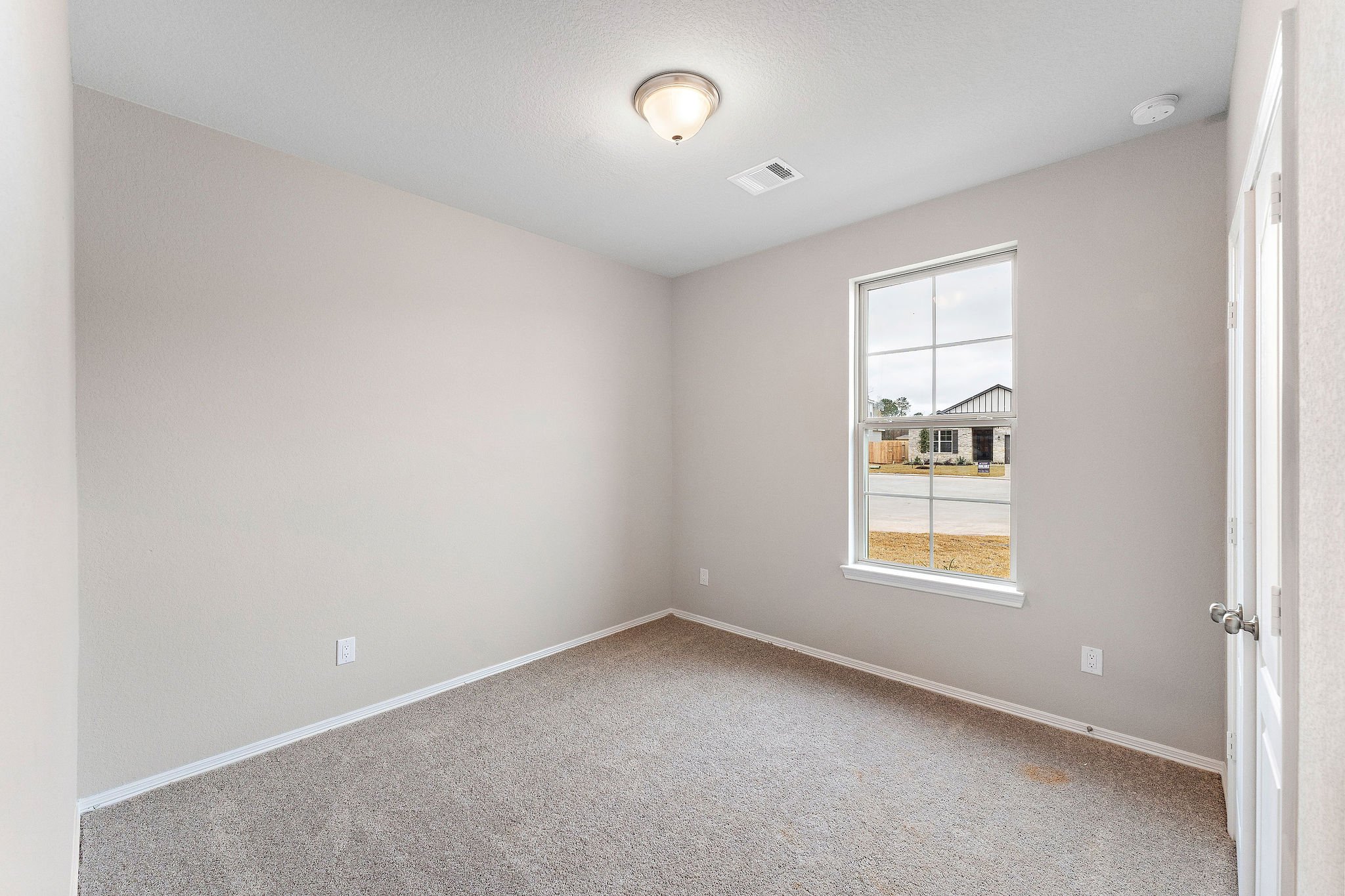 A room with a window and carpet.