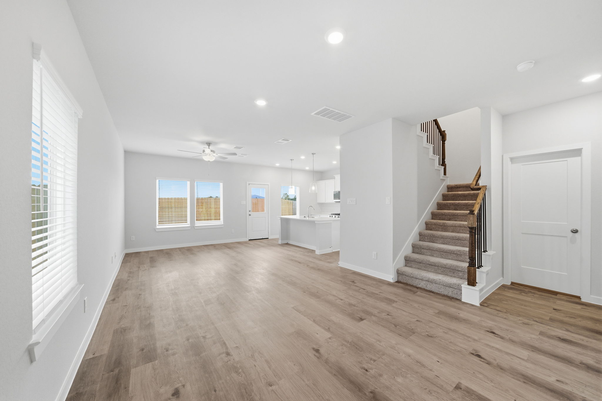 A large empty room with a wood floor and white walls.