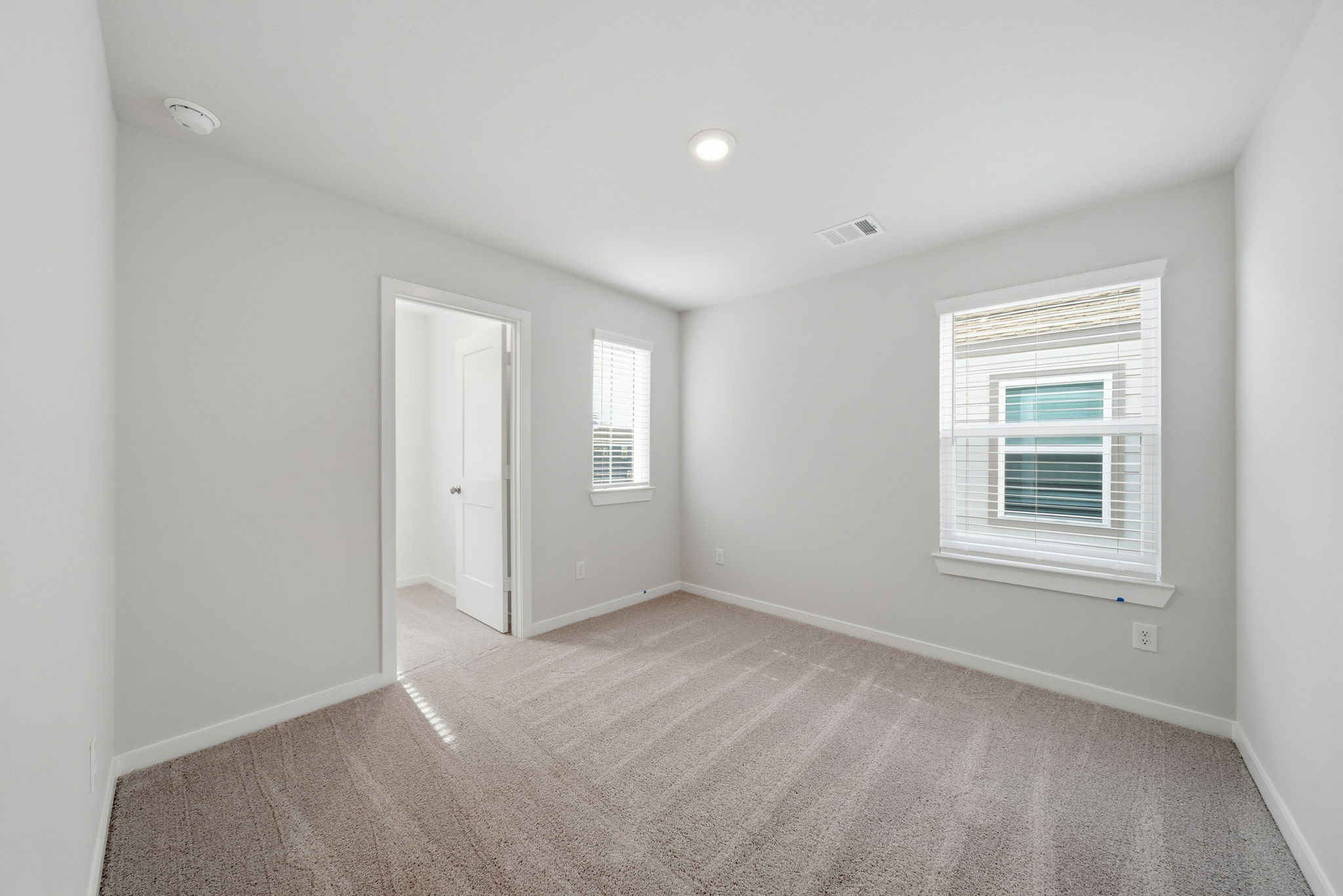 A room with a carpet and windows.